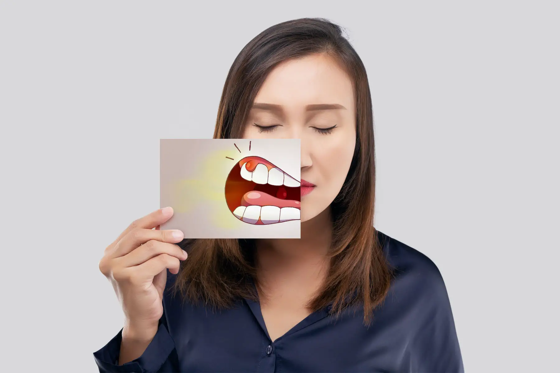 Luxembourg dentists: a woman suffering a toothache and gum inflammation 
