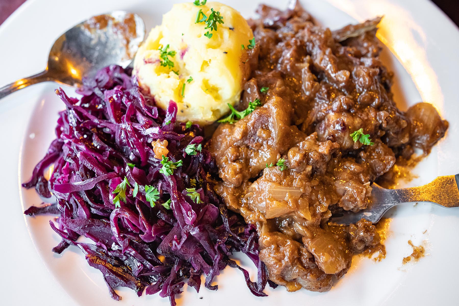 Hachee is typically served with mashed potatoes and red cabbage.