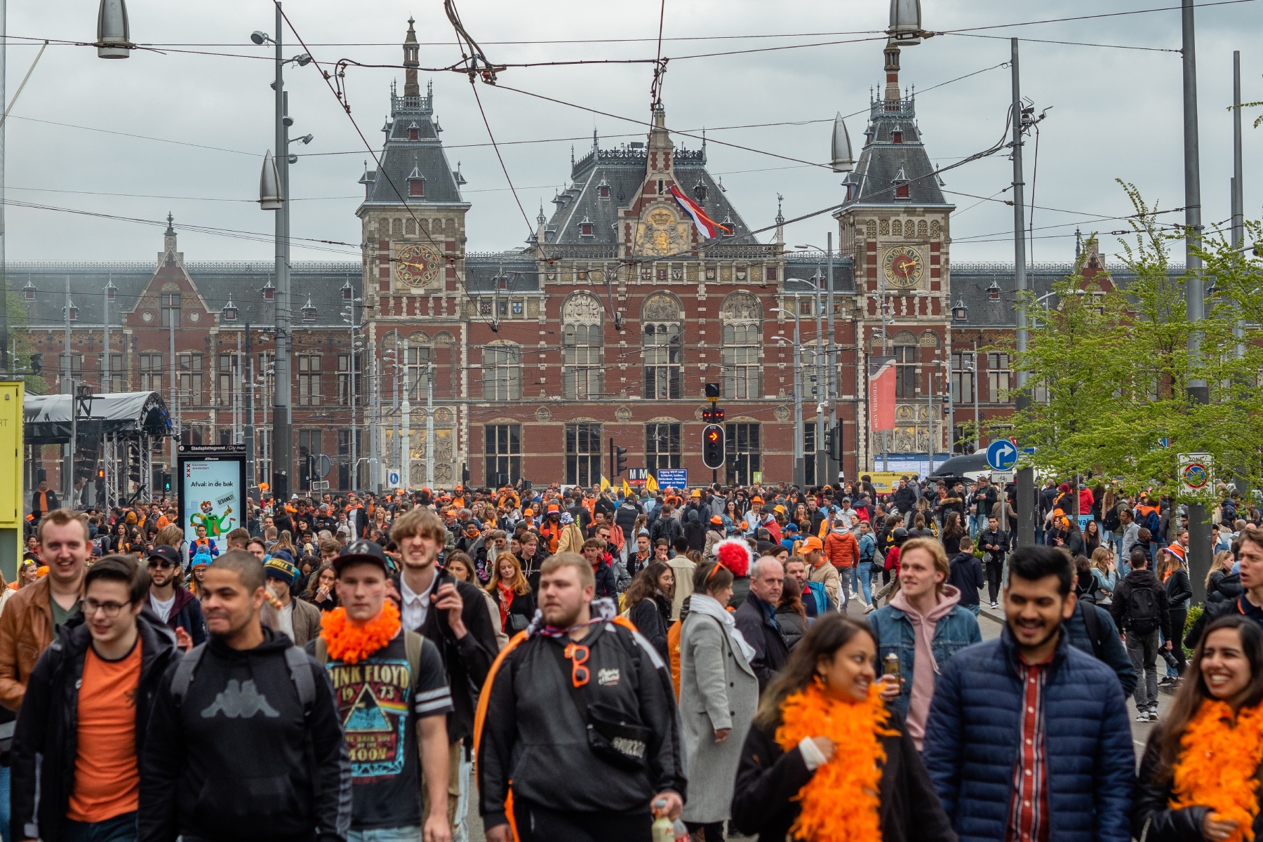 Hoards of people wearing orange and walking in front of Rijksmuseum in Amsterdam to celebrate King's Day