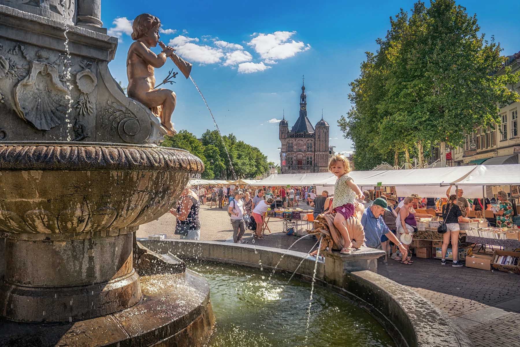 Dutch child playing in a fountain on the square in Deventer city center