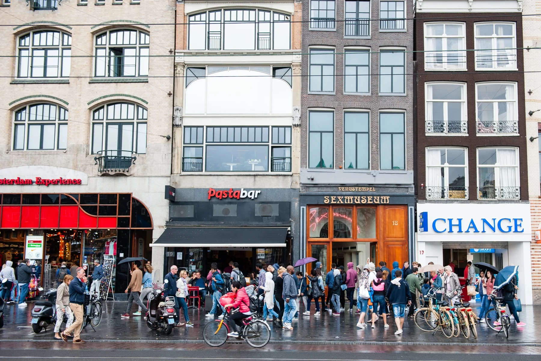 Crowds walking on the pavement in Amsterdam city center on a rainy day