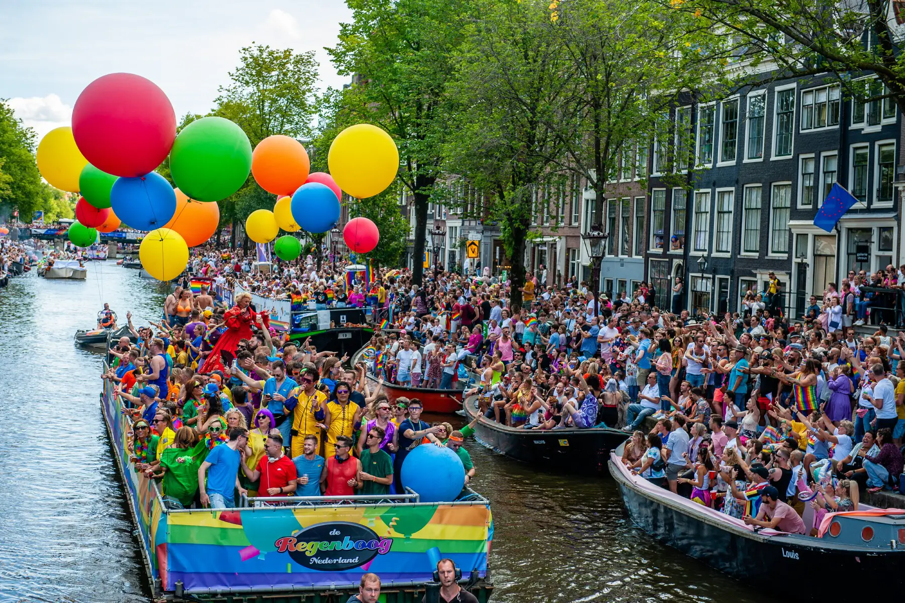 Float with balloons sails through busy Canal Parade in Amsterdam