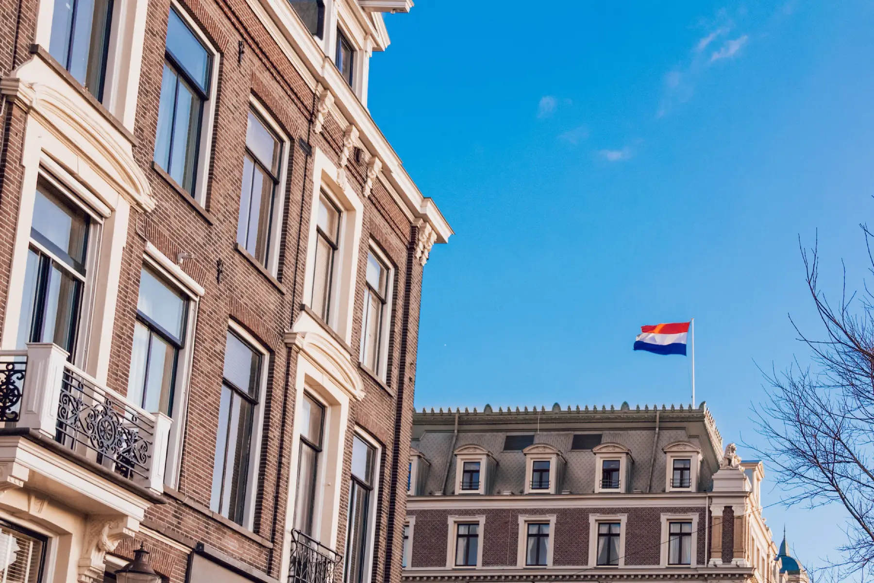 Apartment buildings in Amsterdam with Dutch flag flying on mast