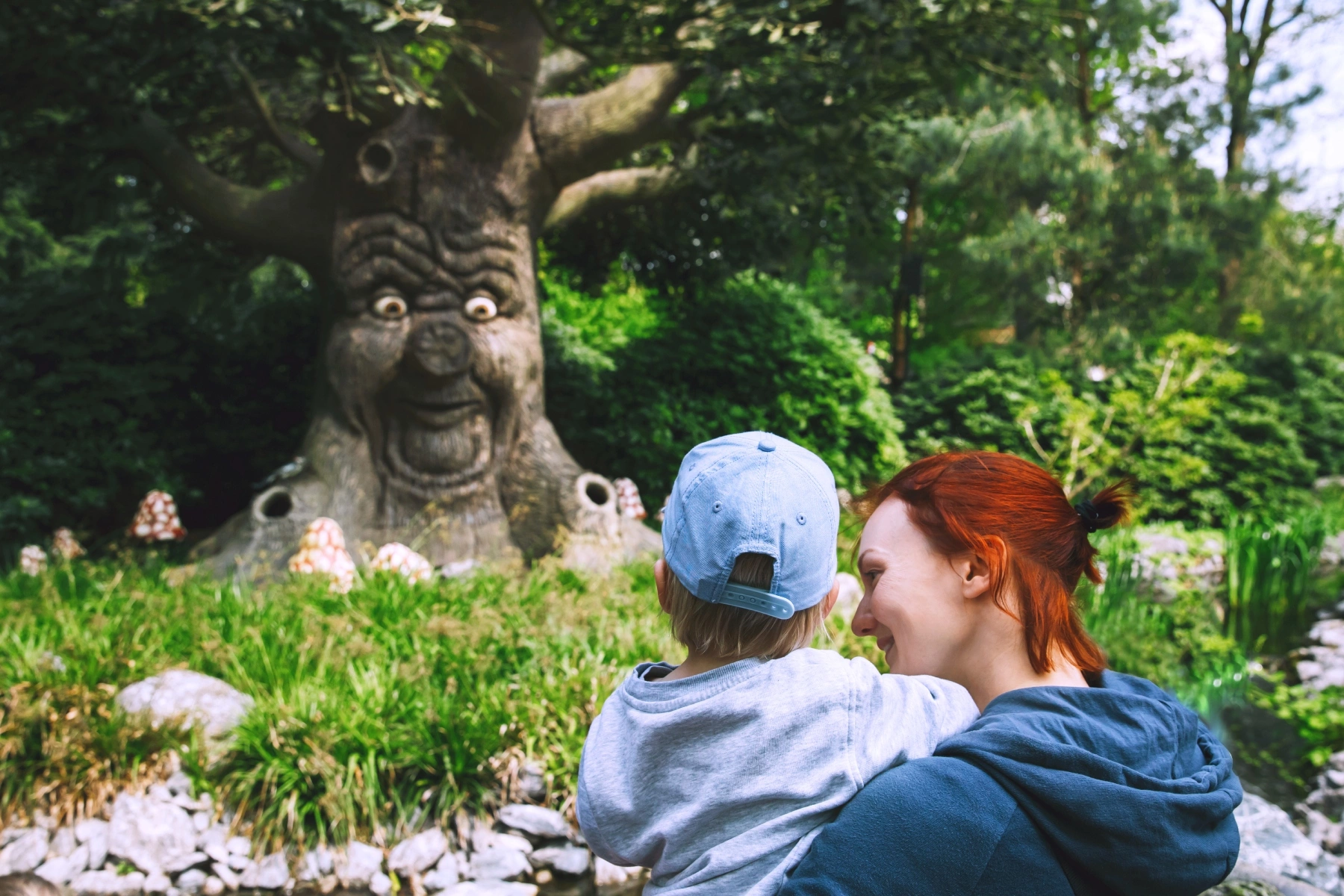 Mother holding child looking at fairy tale tree at Efteling  theme park