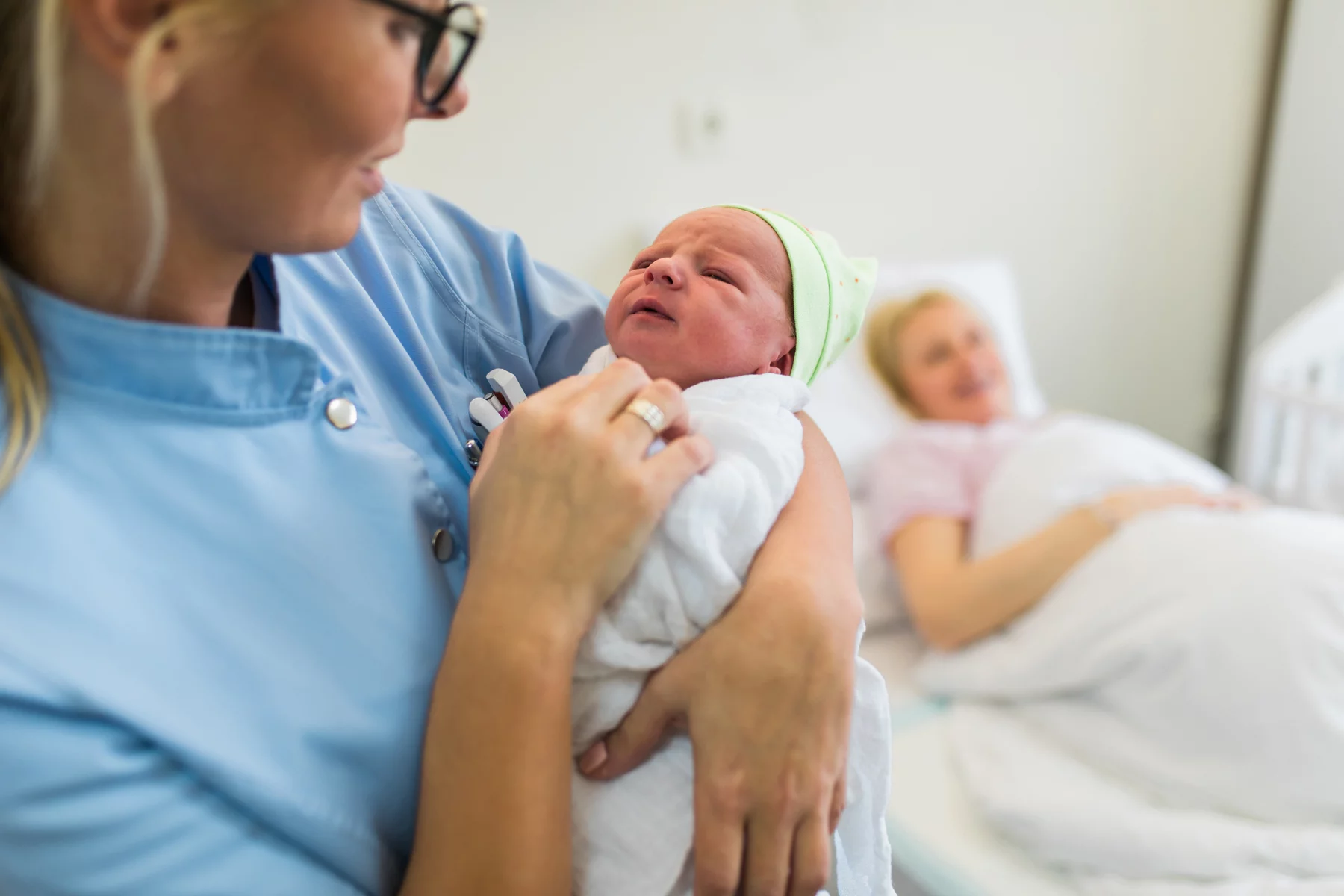 Maternity nurse holding newborn baby