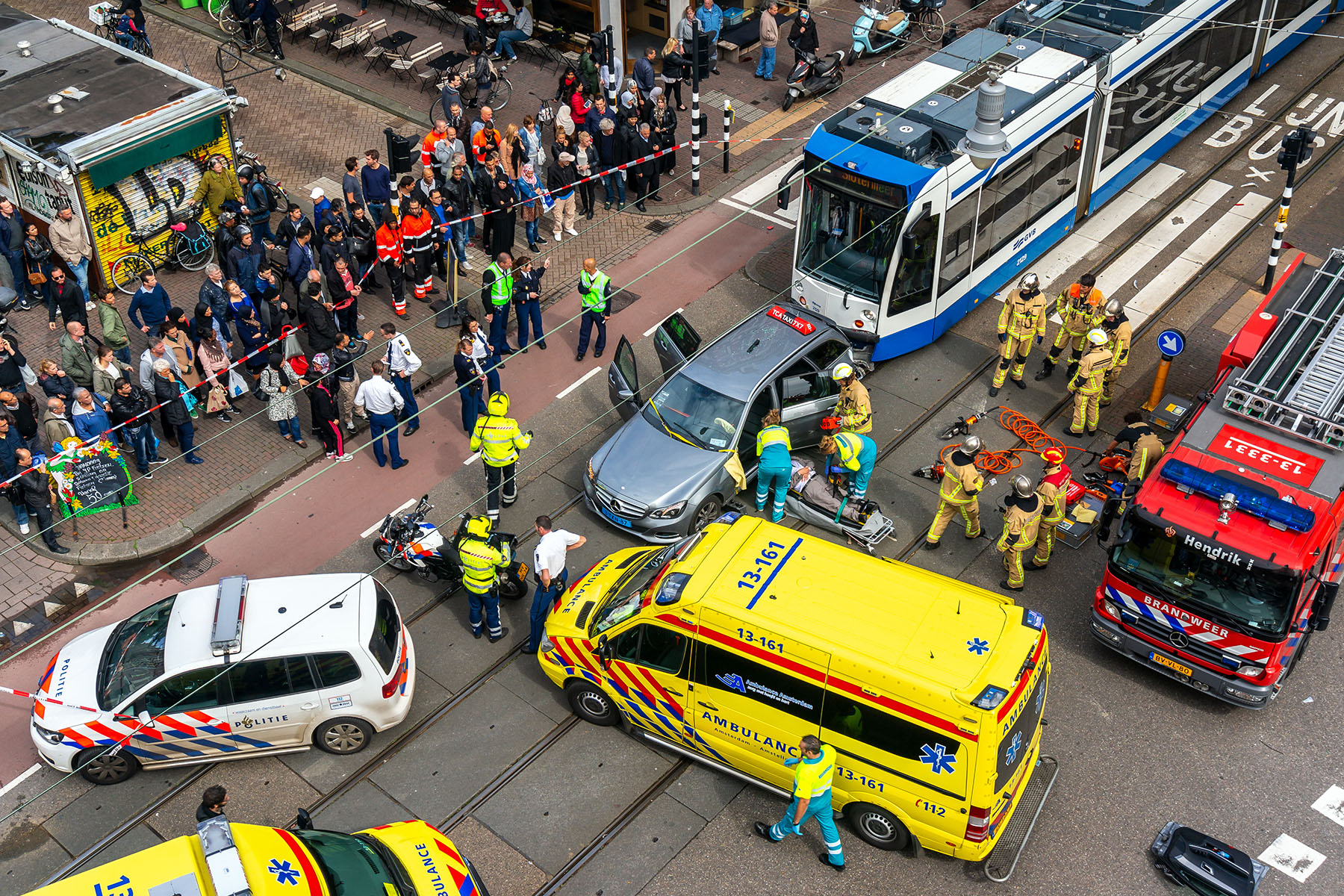 Birds-eye view of emergency services, police, fire brigade and ambulance at the scene of a traffic accident with a tram and a car in Amsterdam, the Netherlands