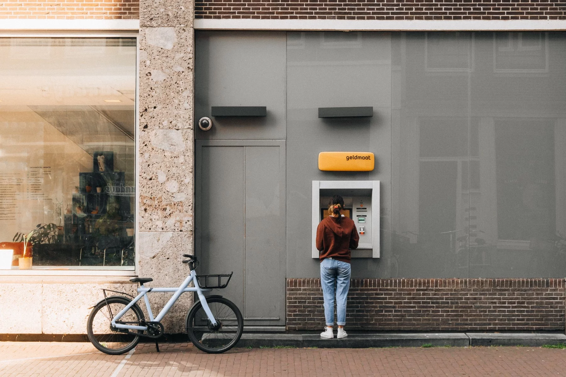 Woman standing with an ATM in the Netherlands.