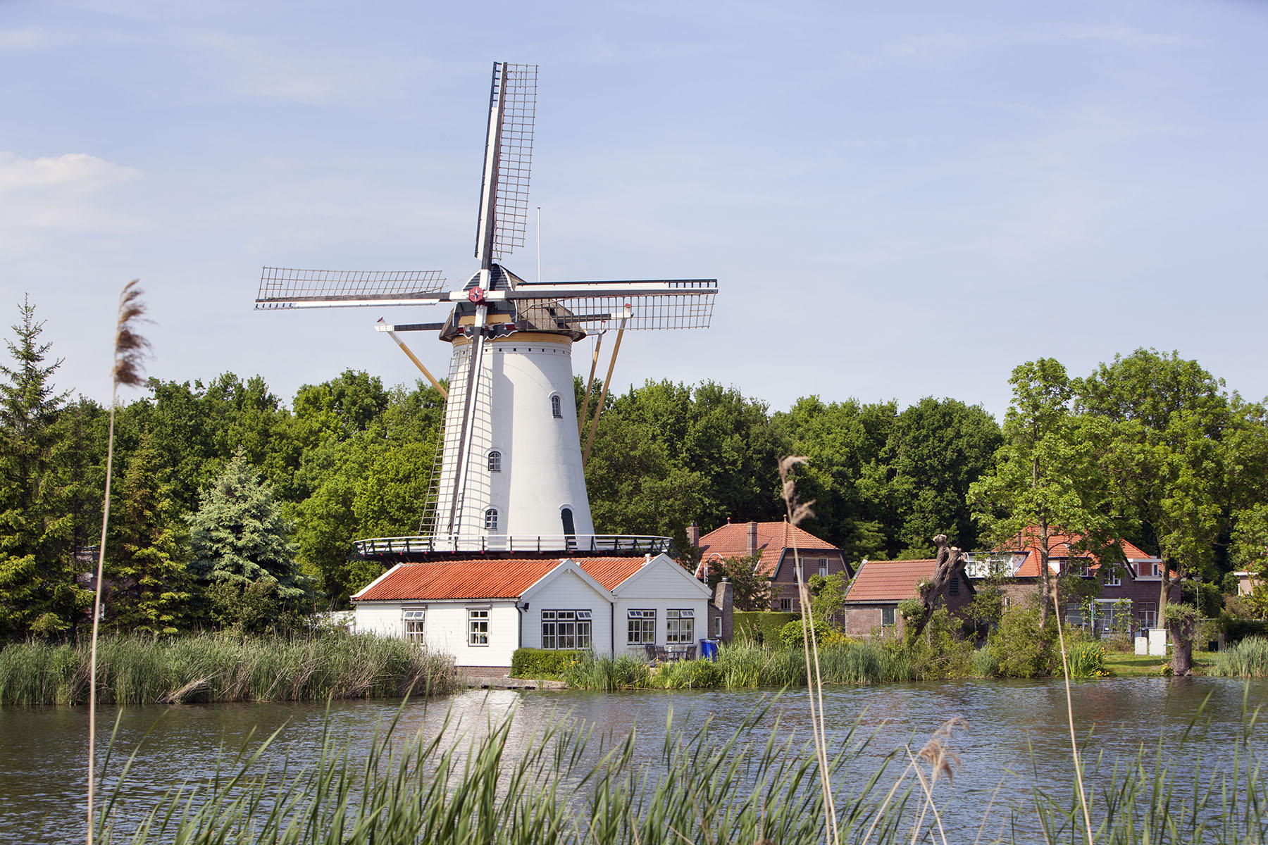A white windmill in Rotterdam-Terbregge beside the river Rotte in the Netherlands.
