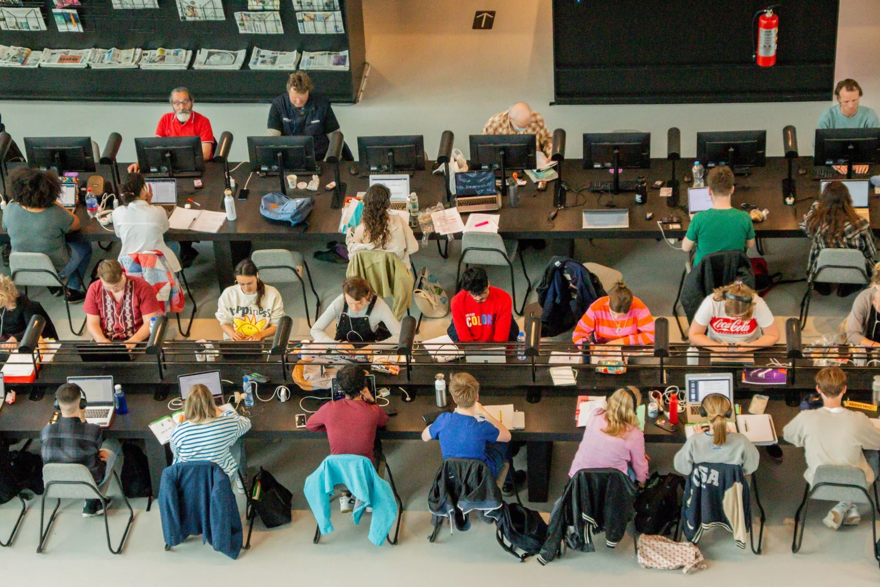 Students sitting at large tables in the University Library of Groningen, the Netherlands.