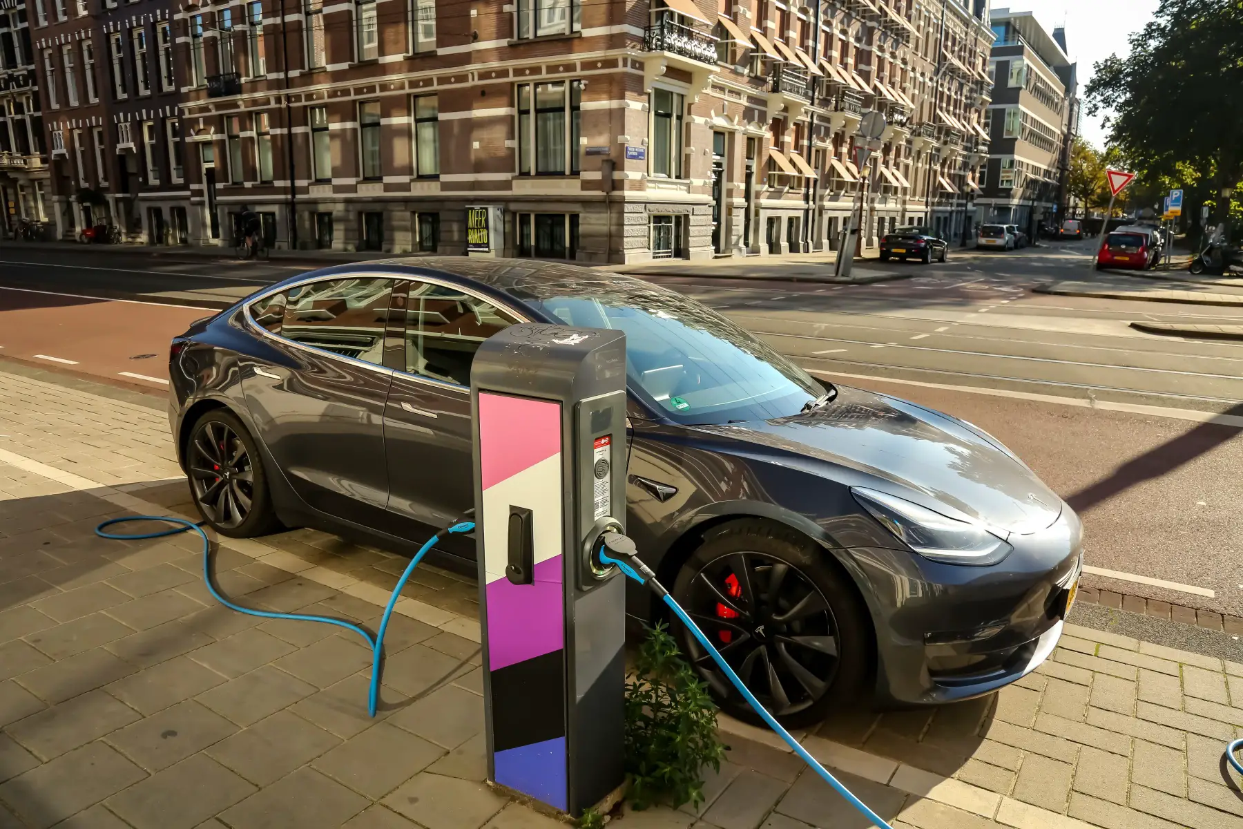 a Tesla parked at a charging station in Amsterdam