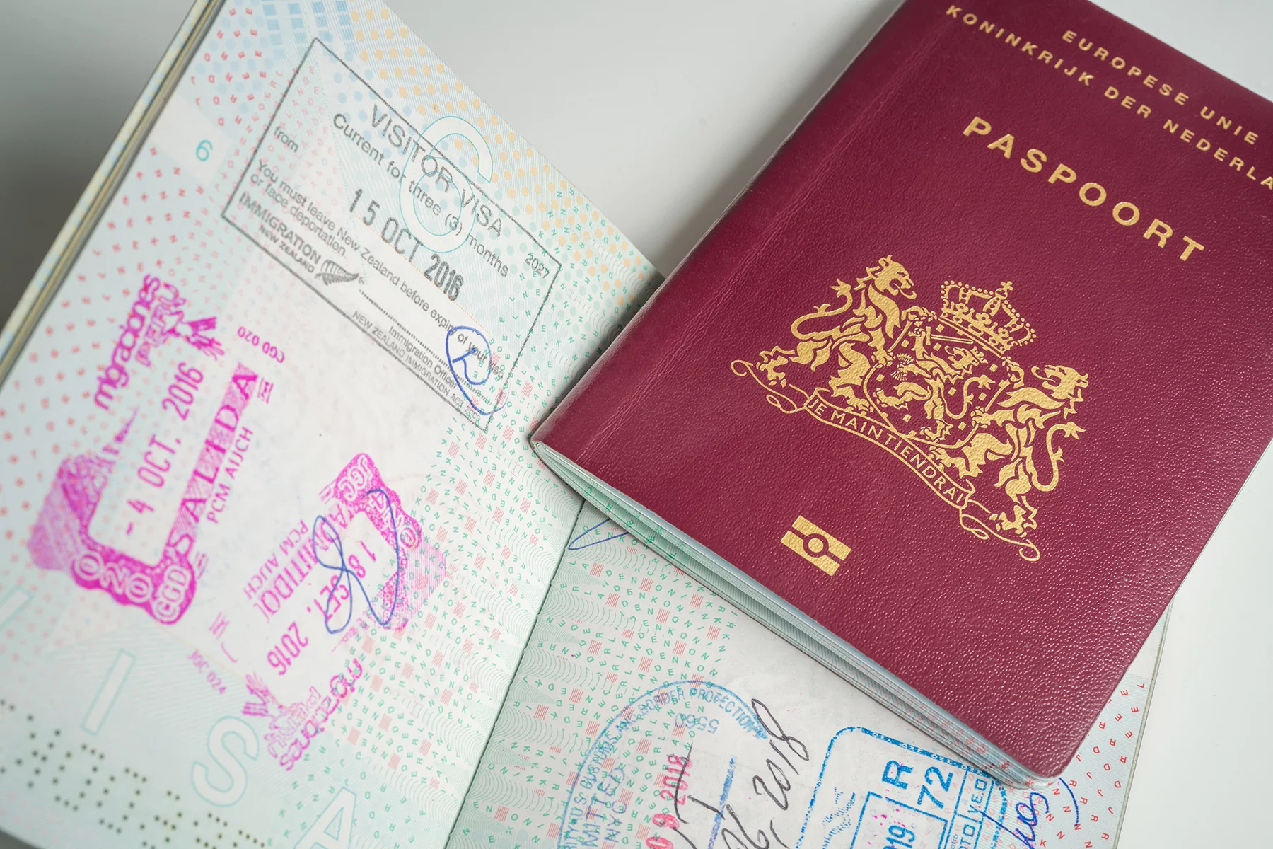 Two Dutch passports, one open with stamps
