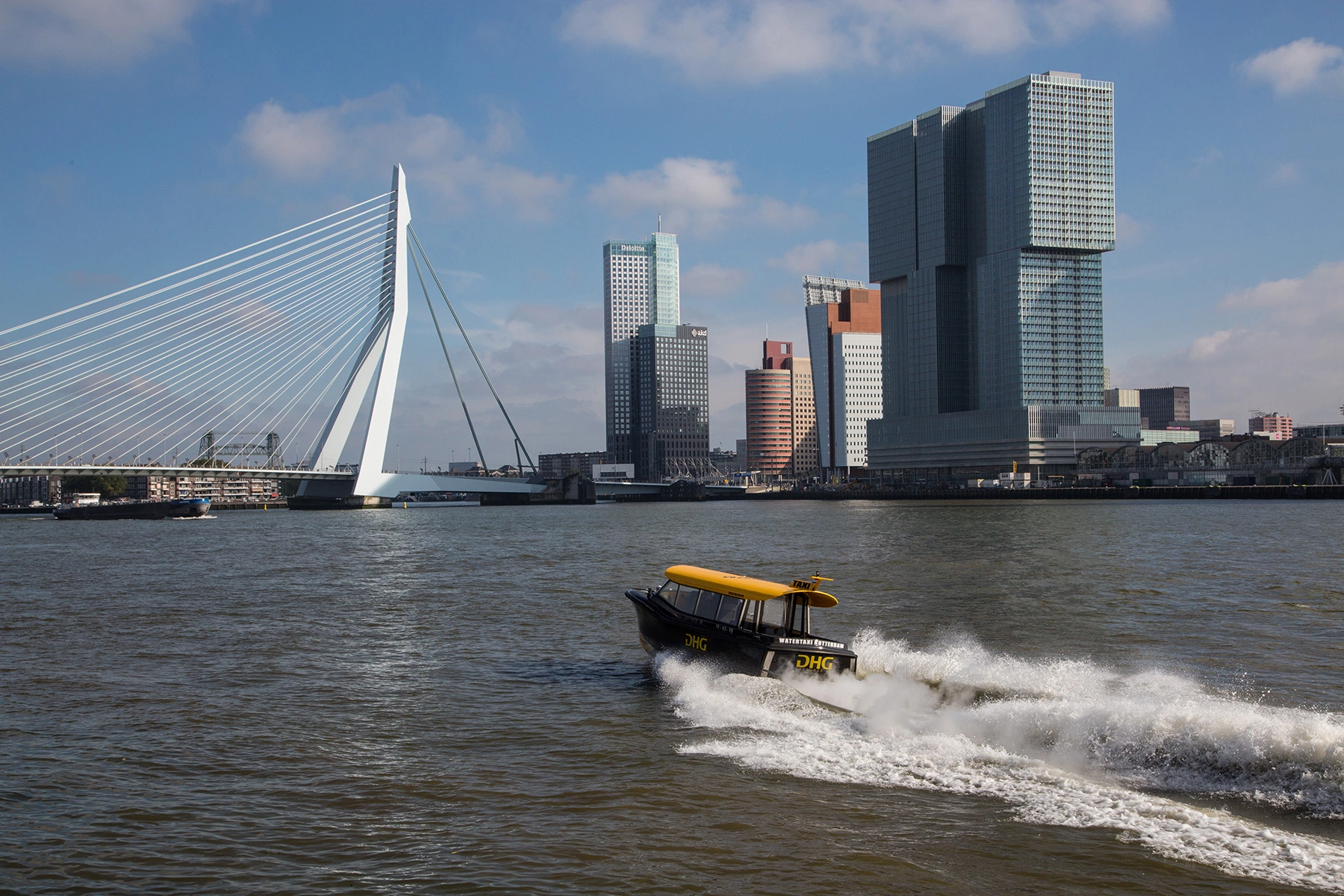 A water taxi speeds towards the Erasmusbrug in Rotterdam