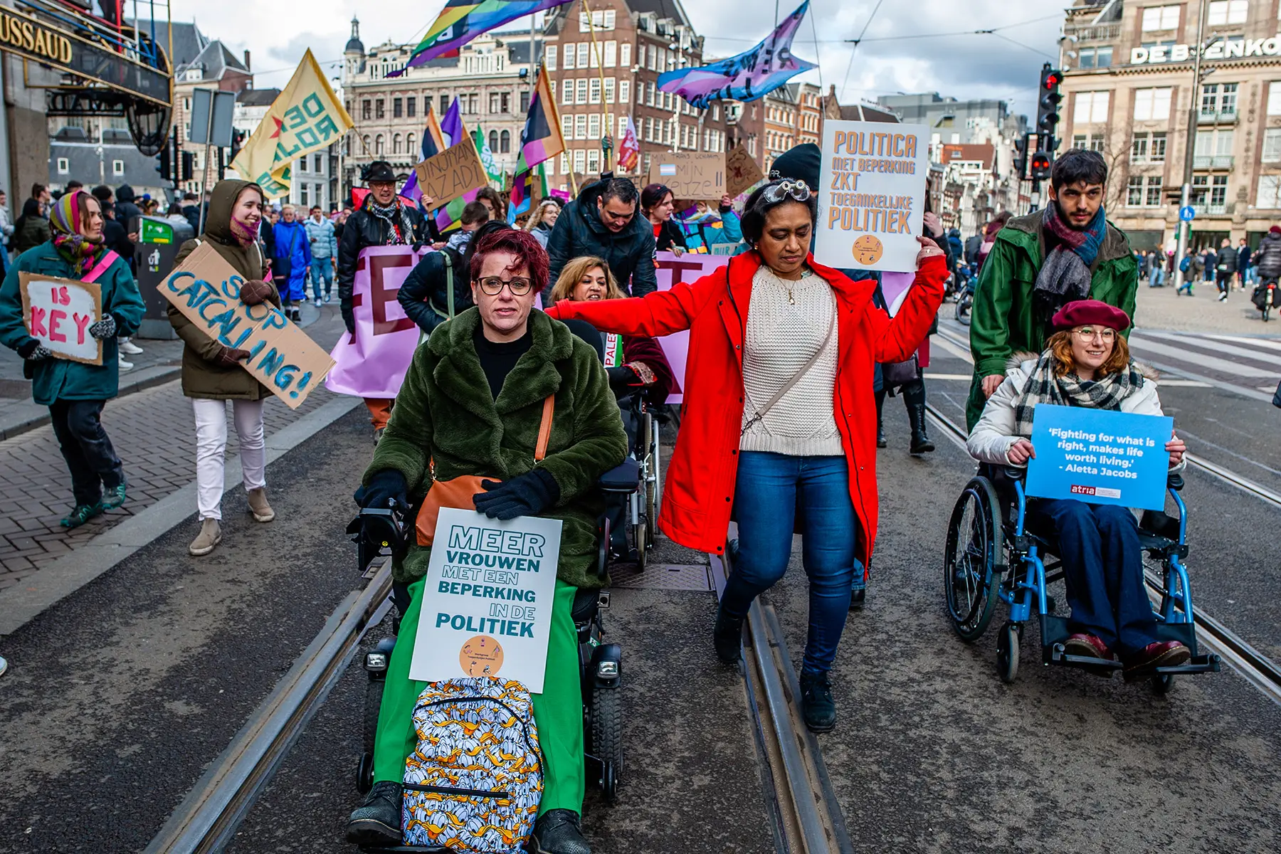 Women in mobility scooters, wheelchairs, and walking with feminist placards