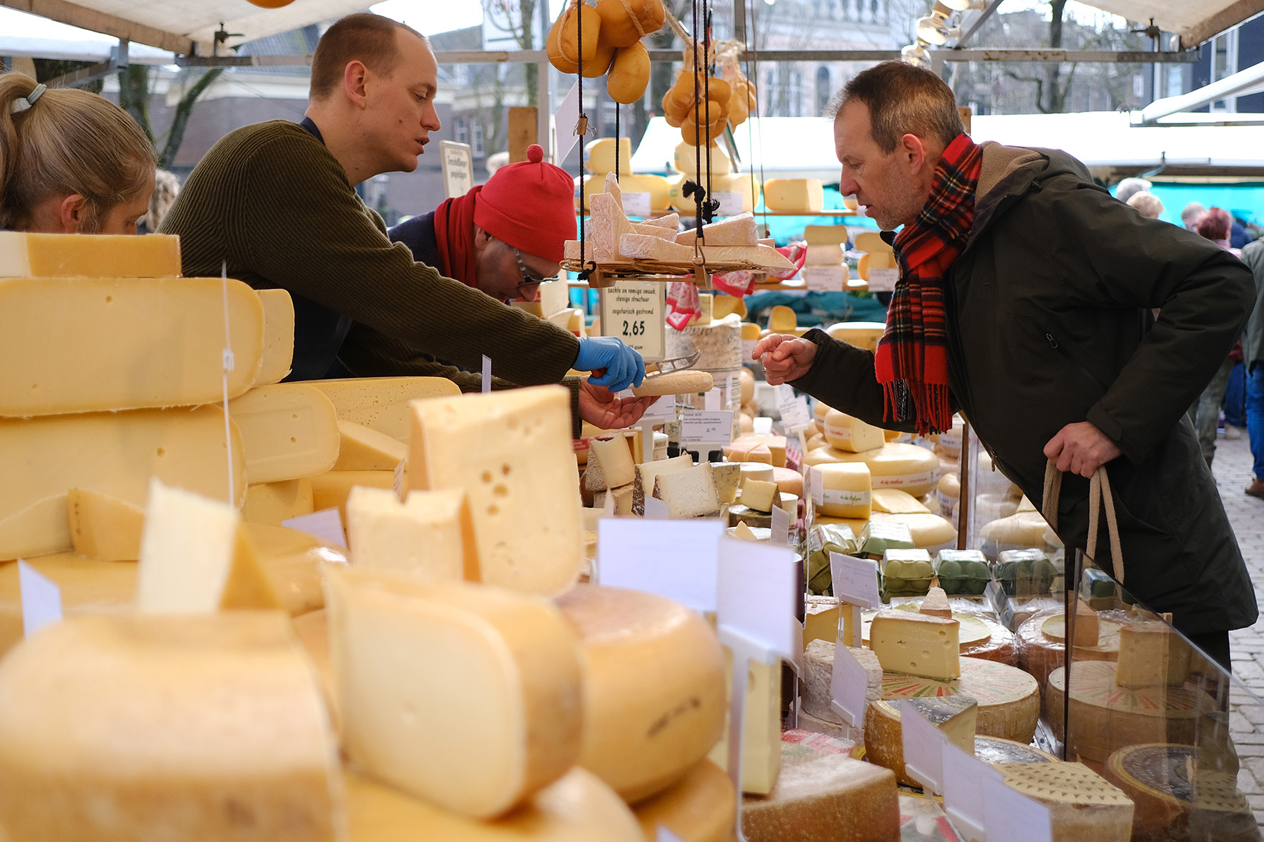 A man looks at a cheese before tasting at an organic farmers market near Northern Church (Noorderkerk) in Amsterdam, Netherlands.