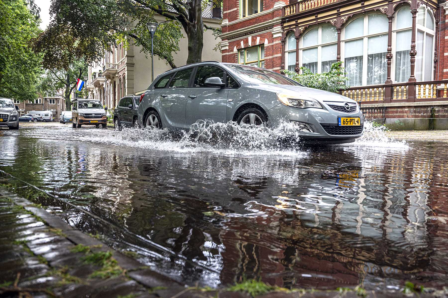 A silver car is driving through a flooded street in Zwolle, the Netherlands.
