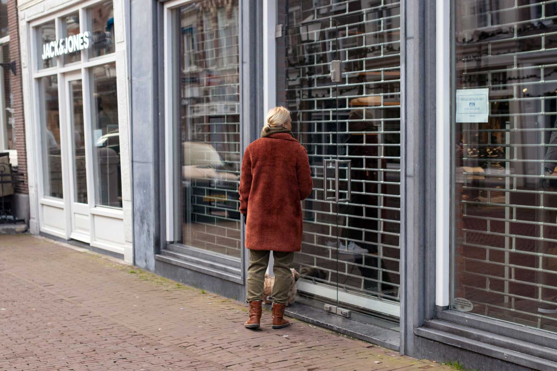 Woman standing in front of a closed store.