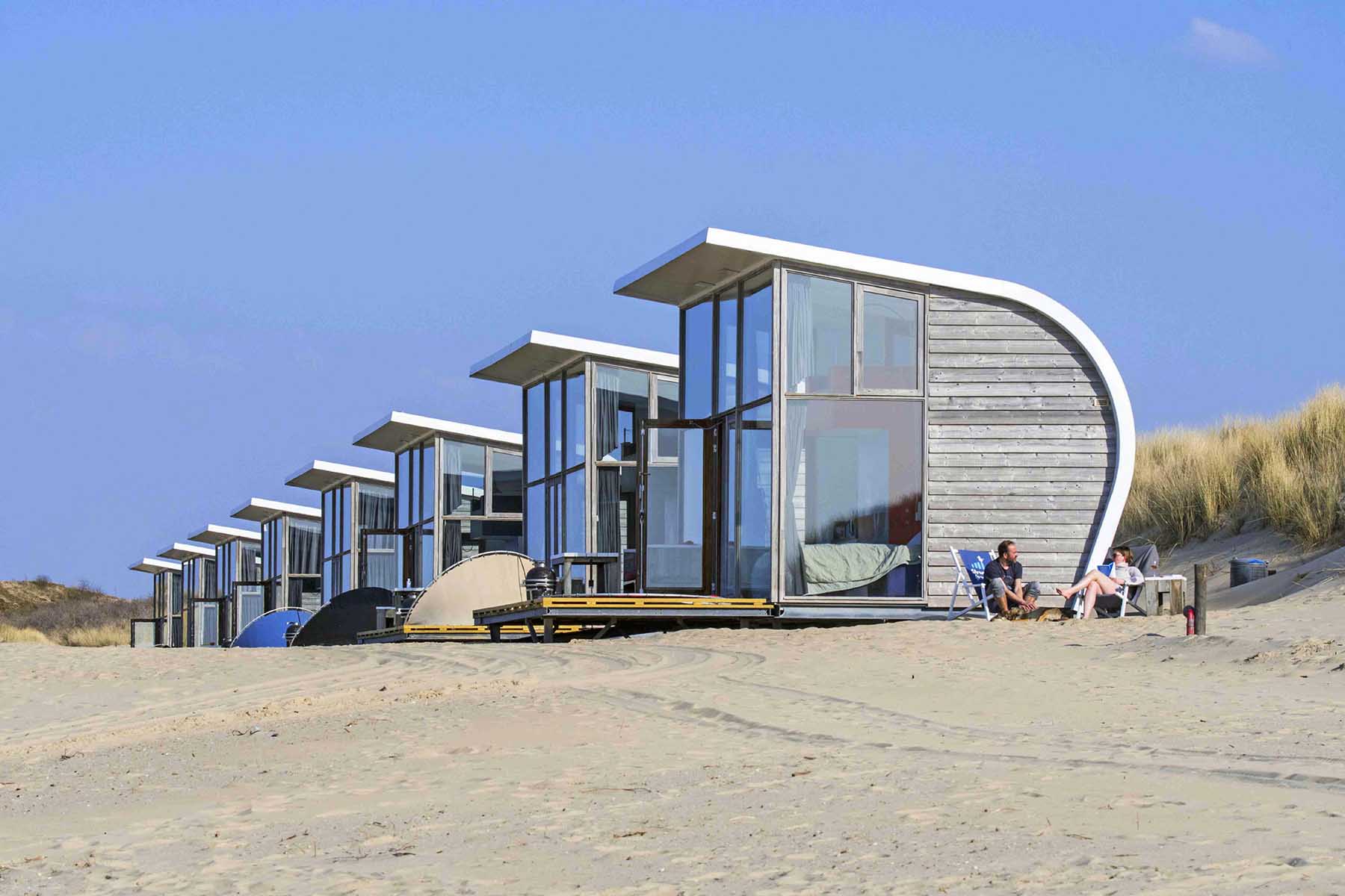 Row of tiny rental houses on sandy beach along the North Sea coast at Groede, the Netherlands.