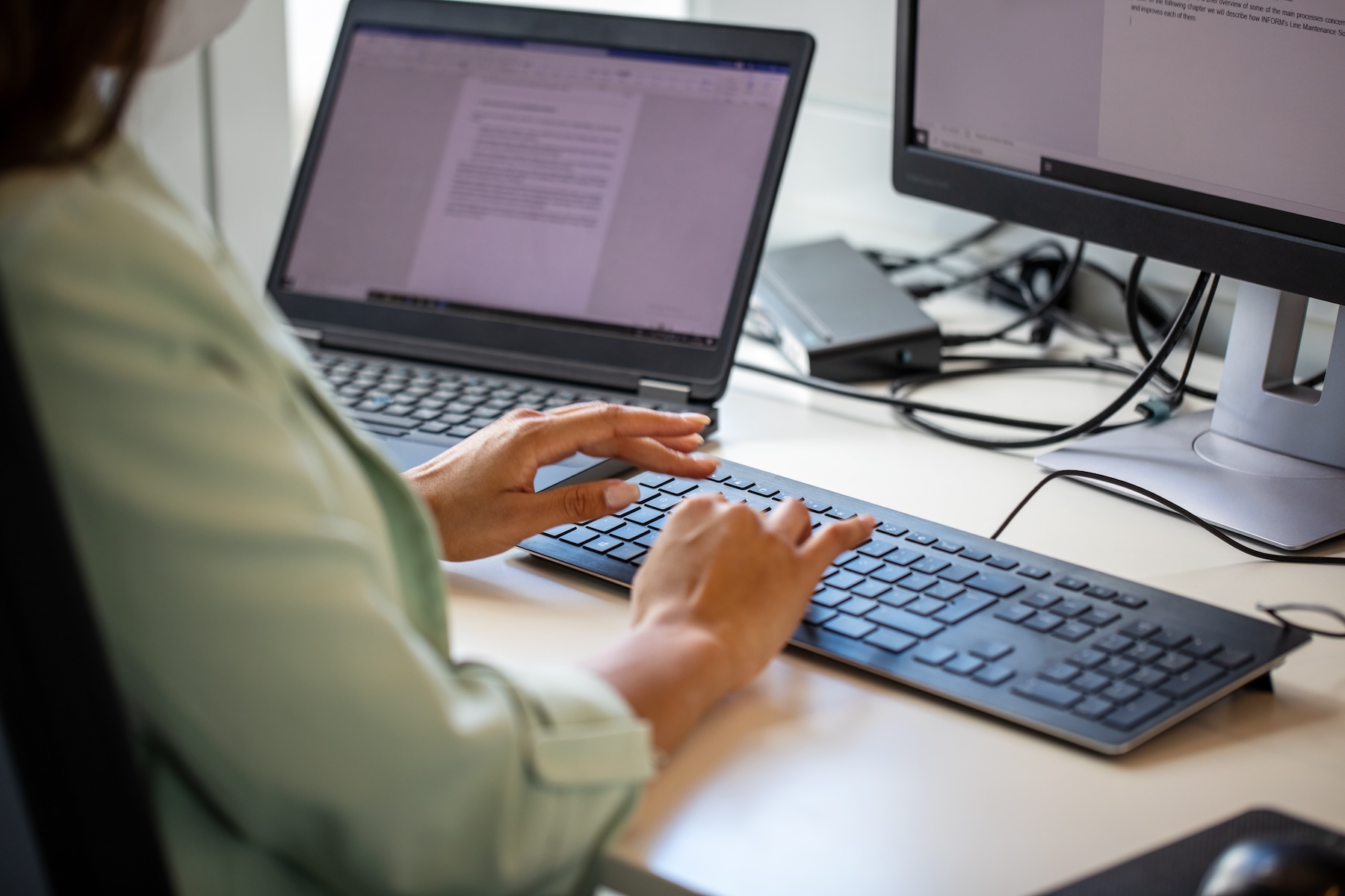 Close-up of woman typing on computer keyboard at workplace