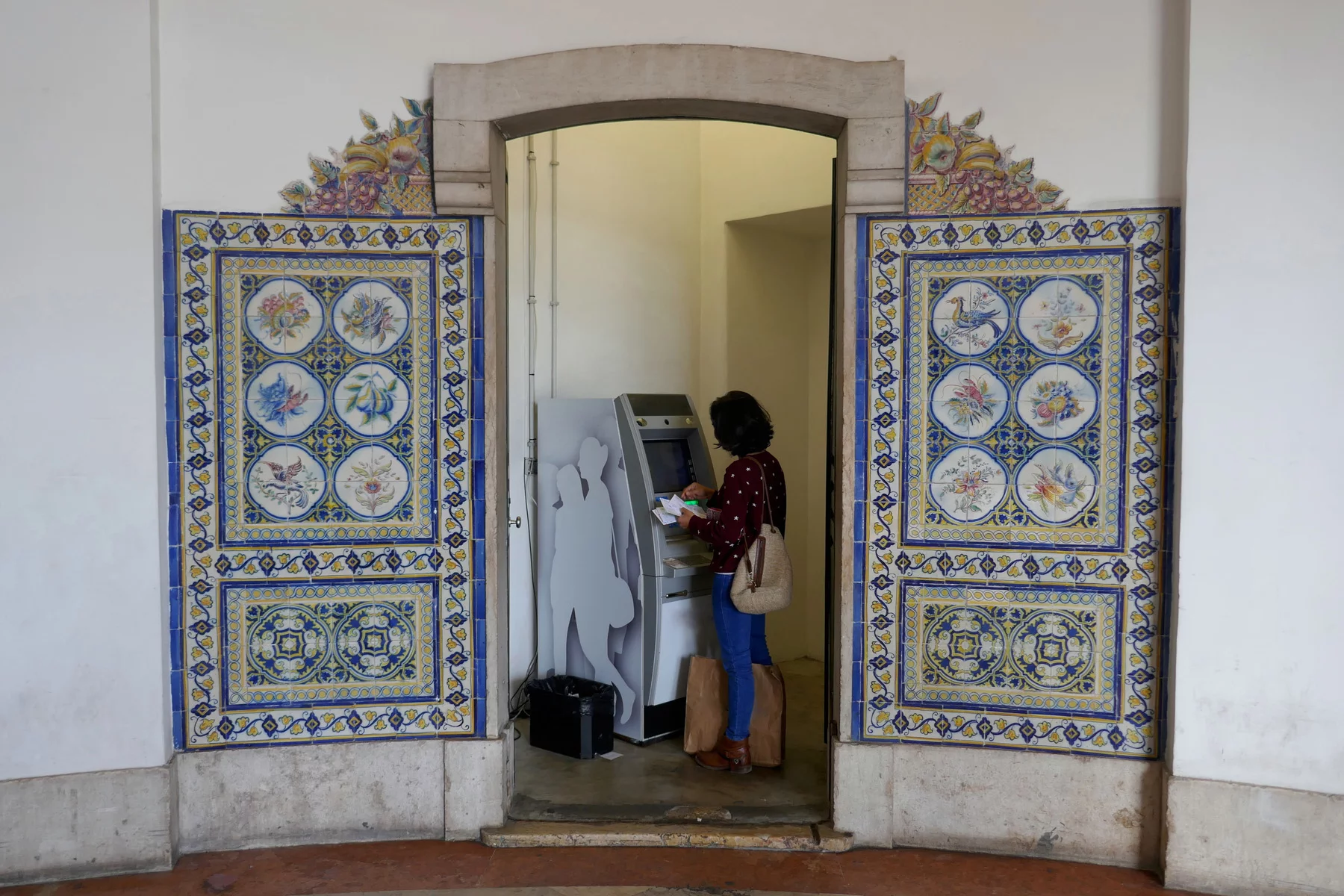 money transfer: a woman makes a withdrawal at a cash machine in Lisbon, Portugal