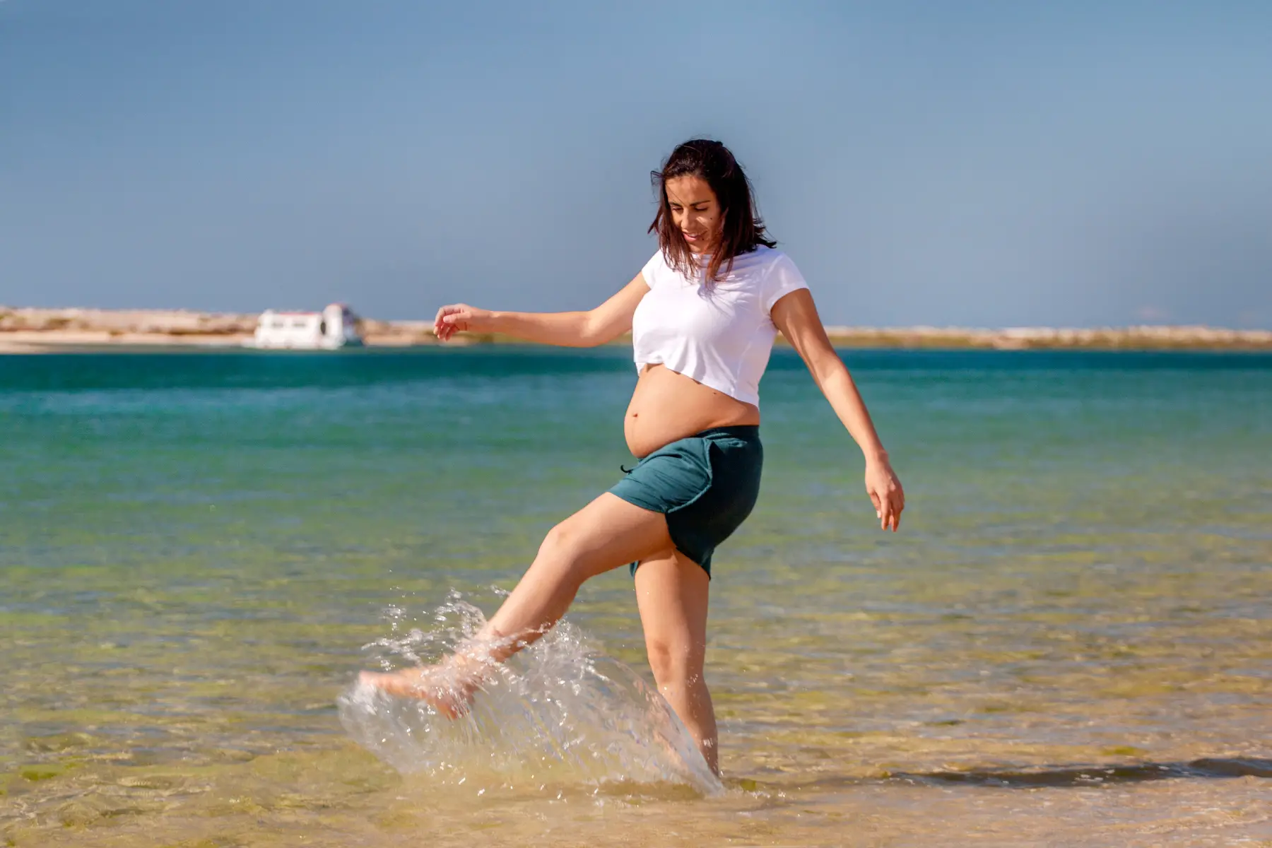 a pregnant woman enjoying a paddle in the ocean 