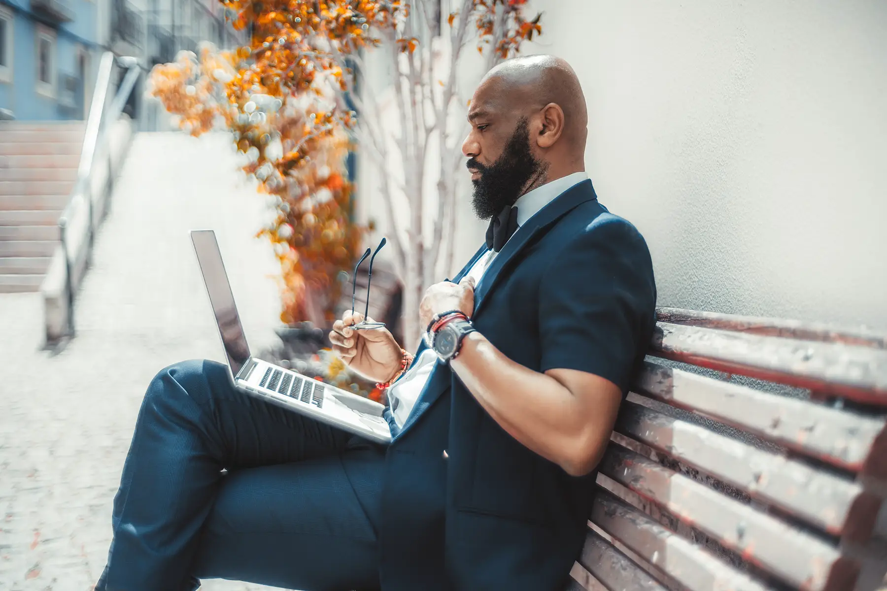 A man sitting on a bench using a laptop