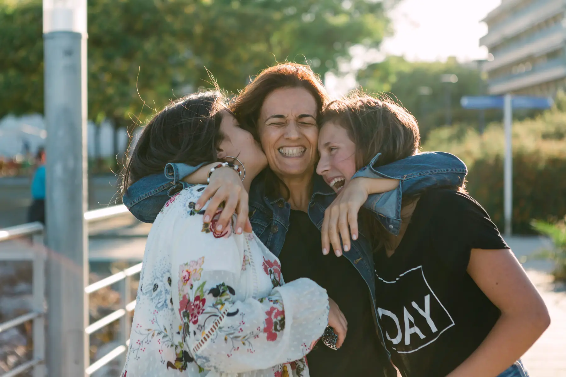 Mothers hugging two daughters excitedly