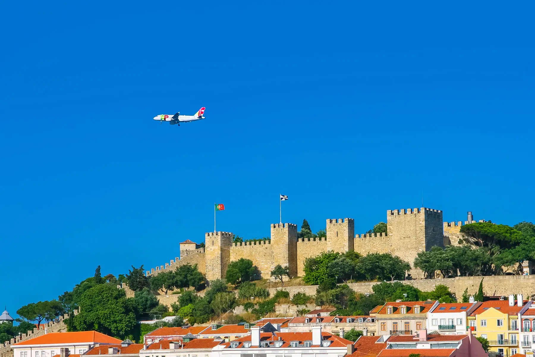 an airplane over Lisbon signals international travel is reopening