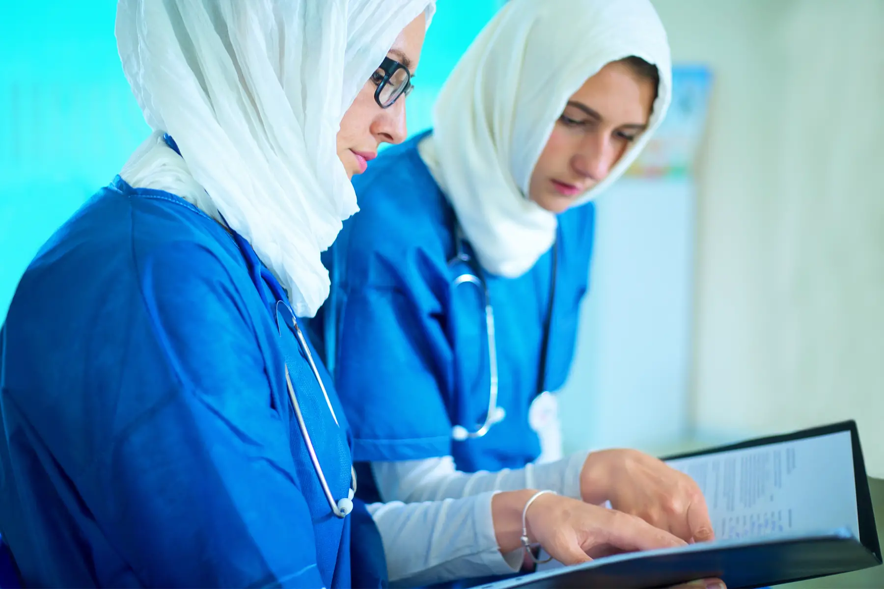 two female doctors confer in Qatar