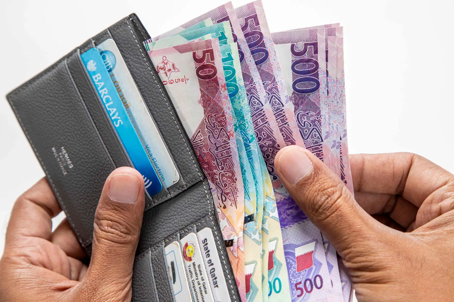 wallet filled with Qatari cash and cards