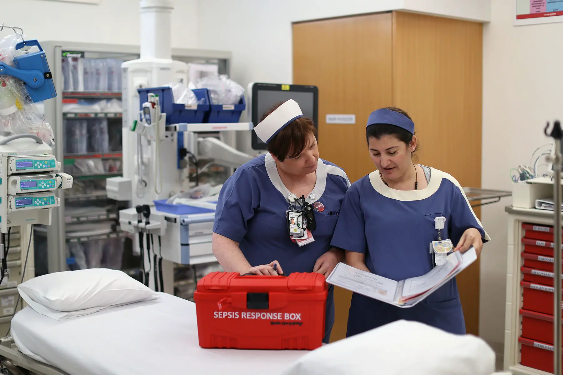 Two medical professionals discussing a procedure for responding to sepsis