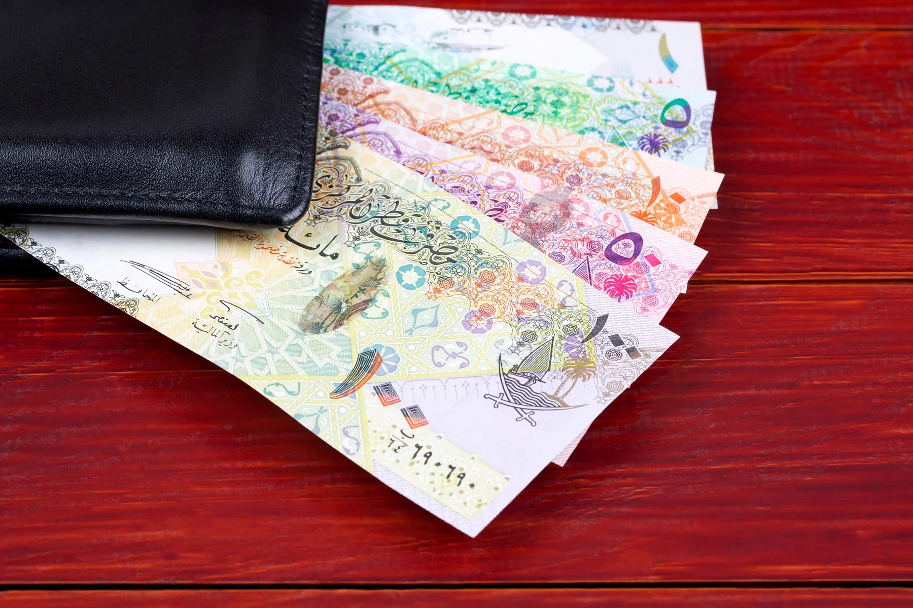 Qatar riyal notes in a wallet