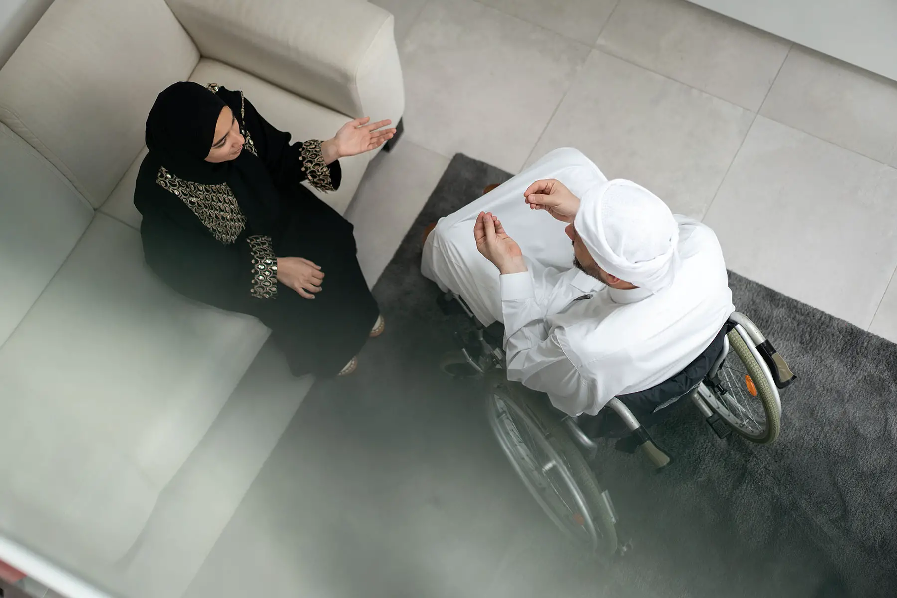 Qatari couple talking, man in wheelchair.