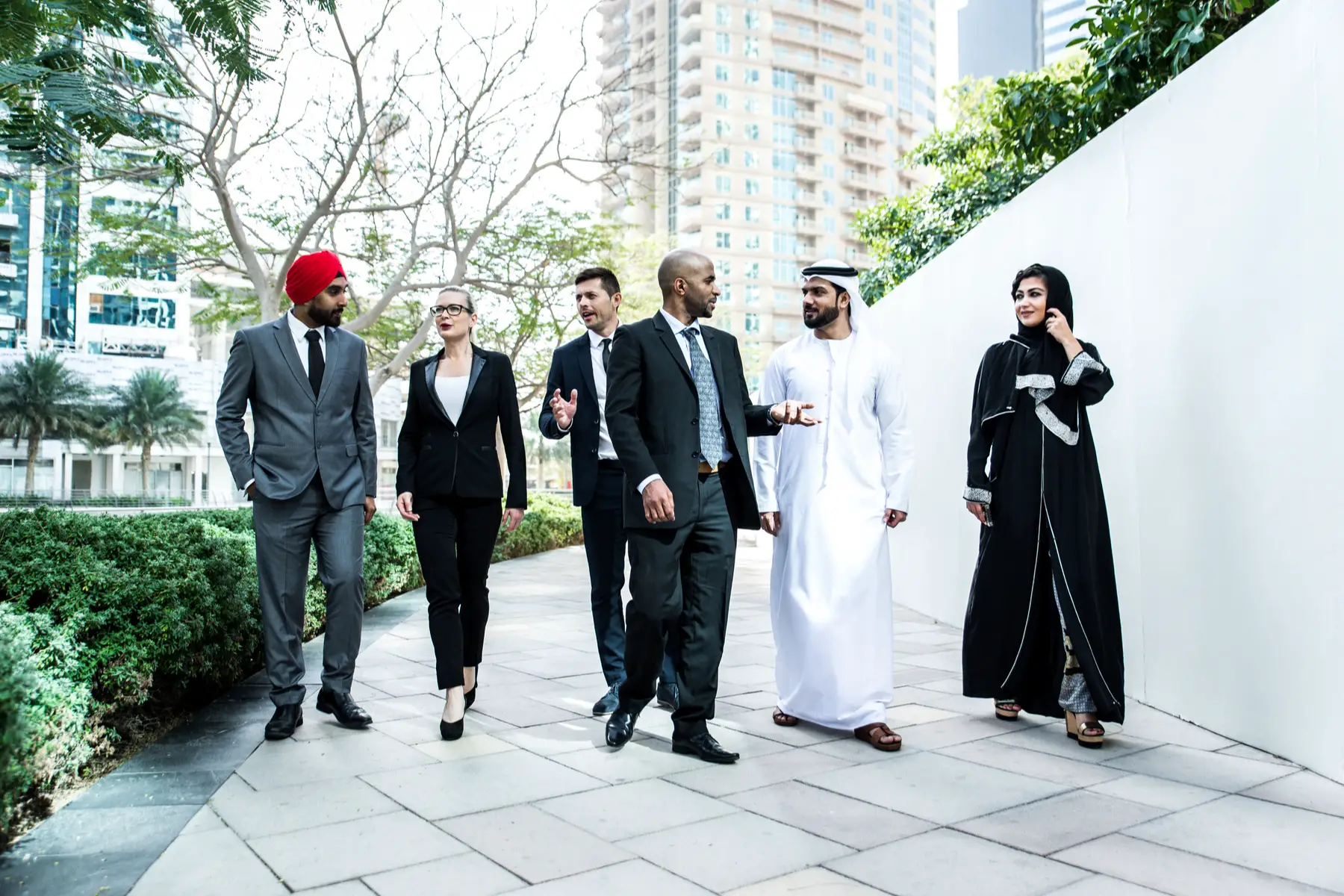 multicultural group of Qatari and expat colleagues in discussion outside the office
