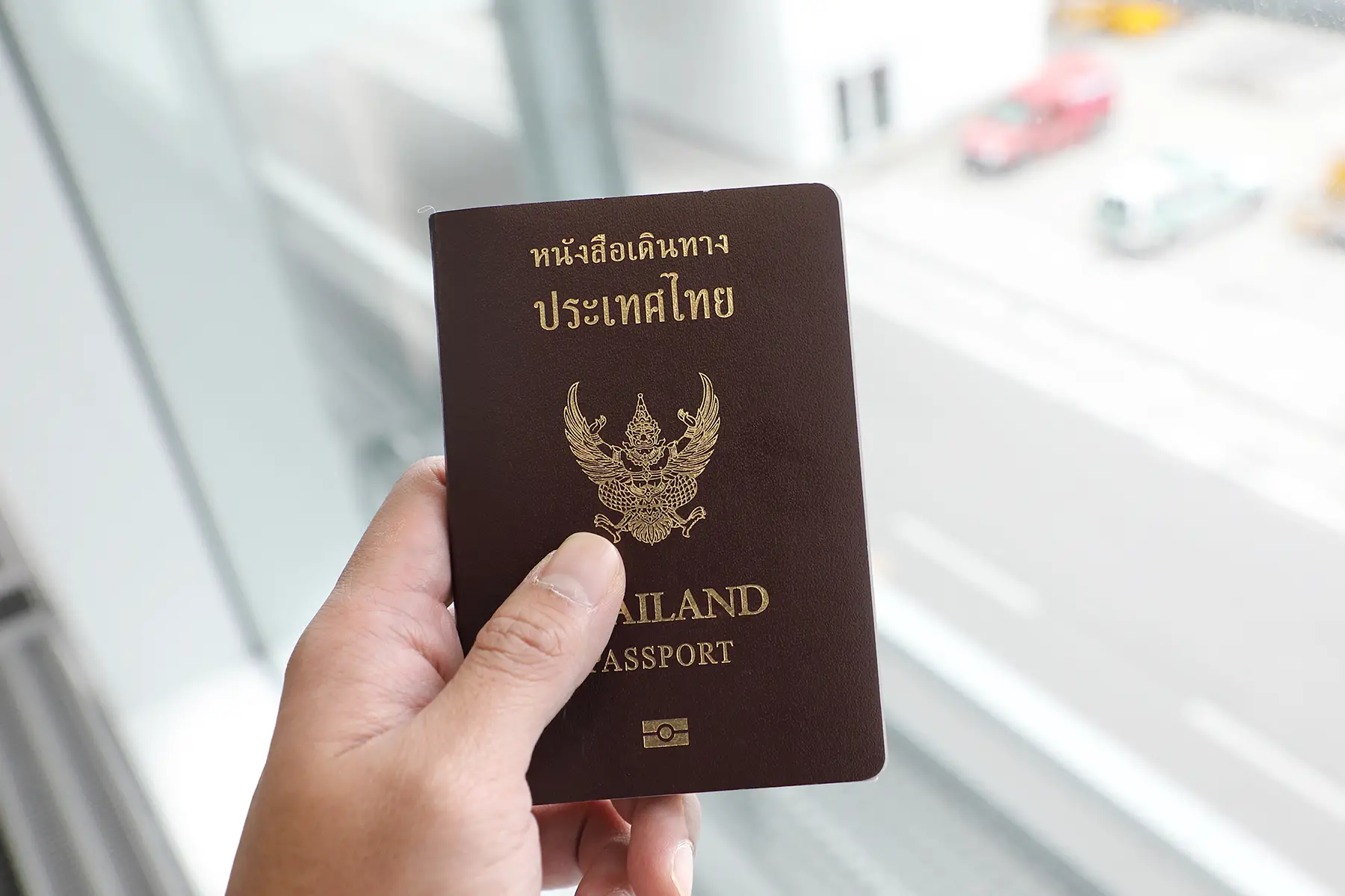 Traveler holding a Thai passport