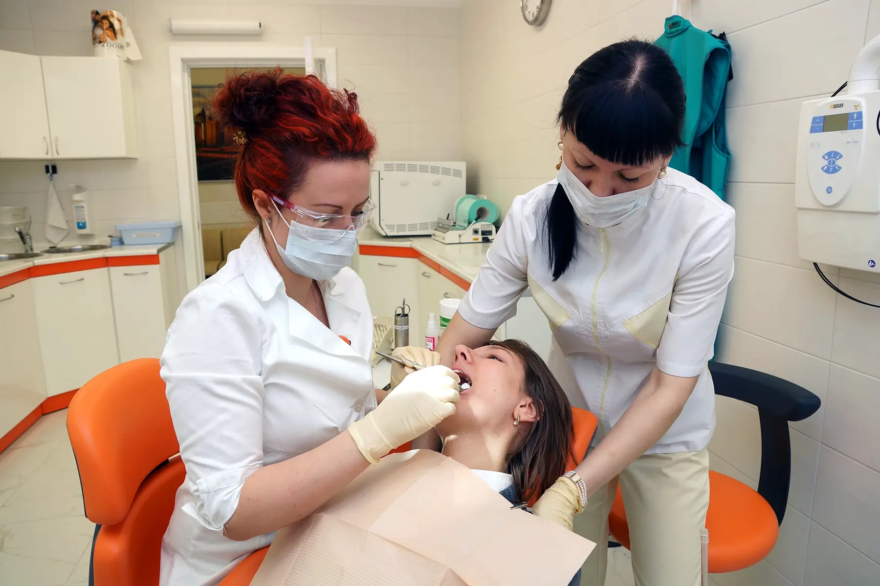 Two dentists carrying out a procedure on a patient