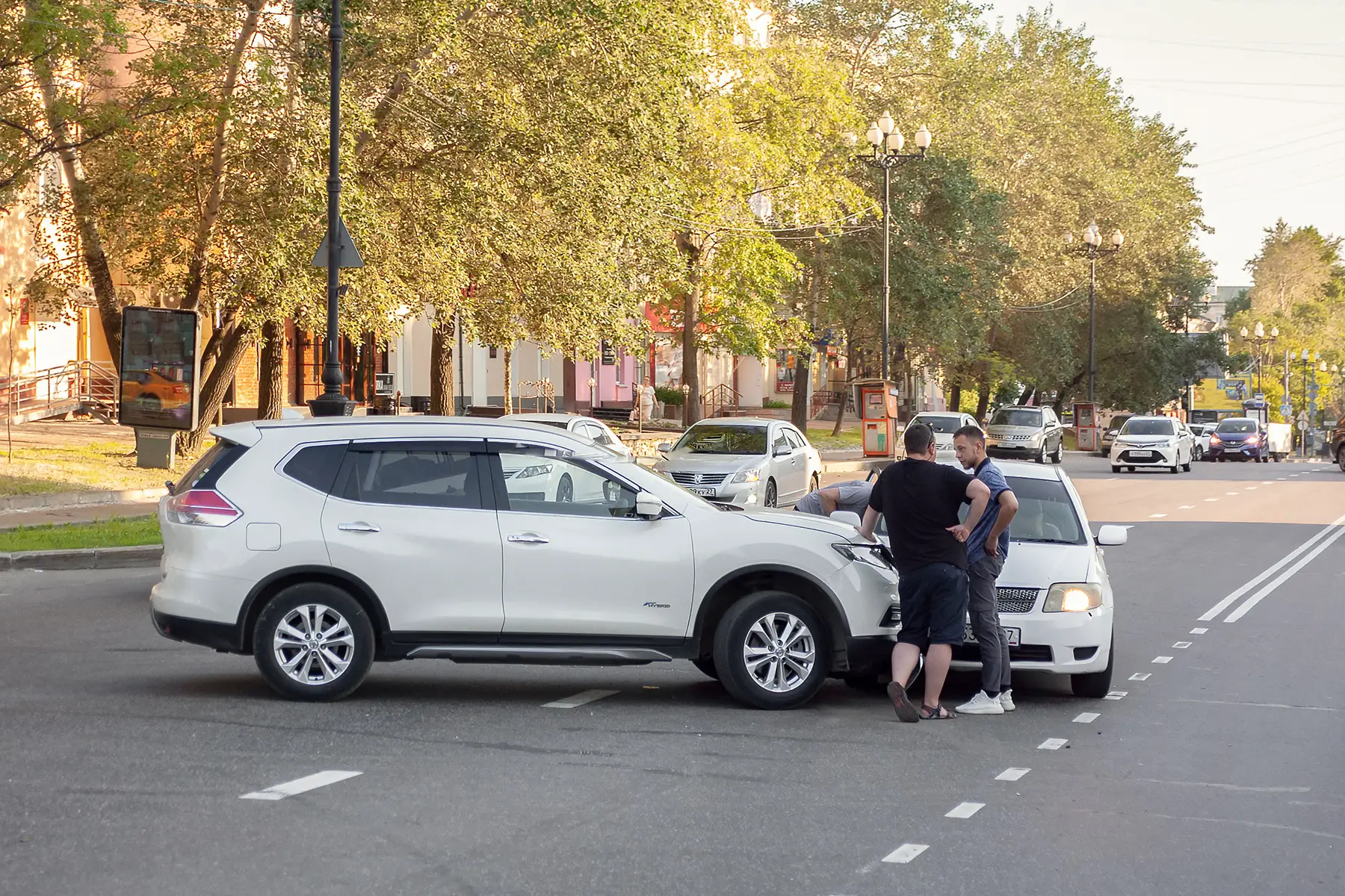 Men talk in the road following a minor traffic collision