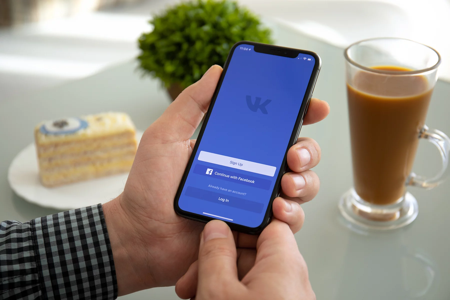 A phone showing Vkontakte app in a café