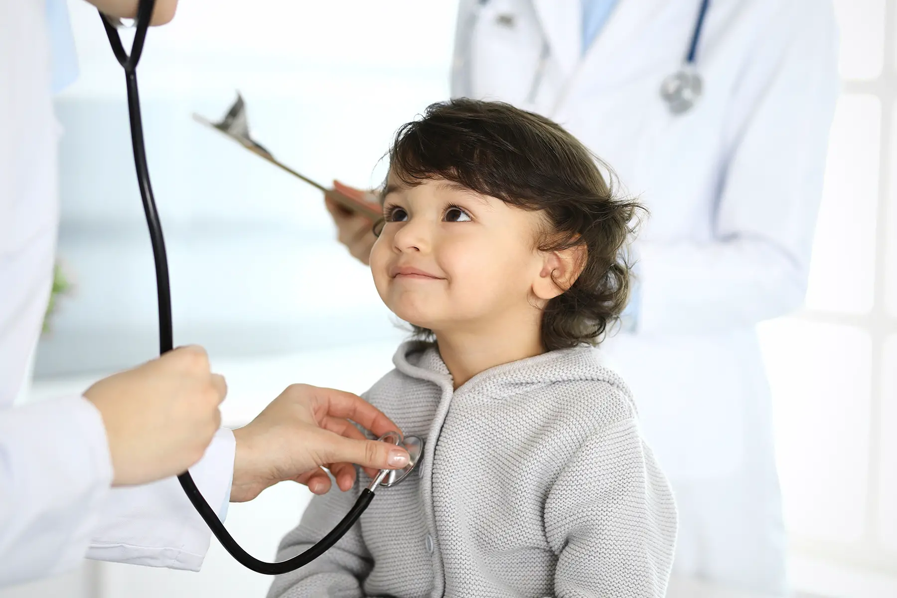 a pediatrician examining a child with a stethoscope