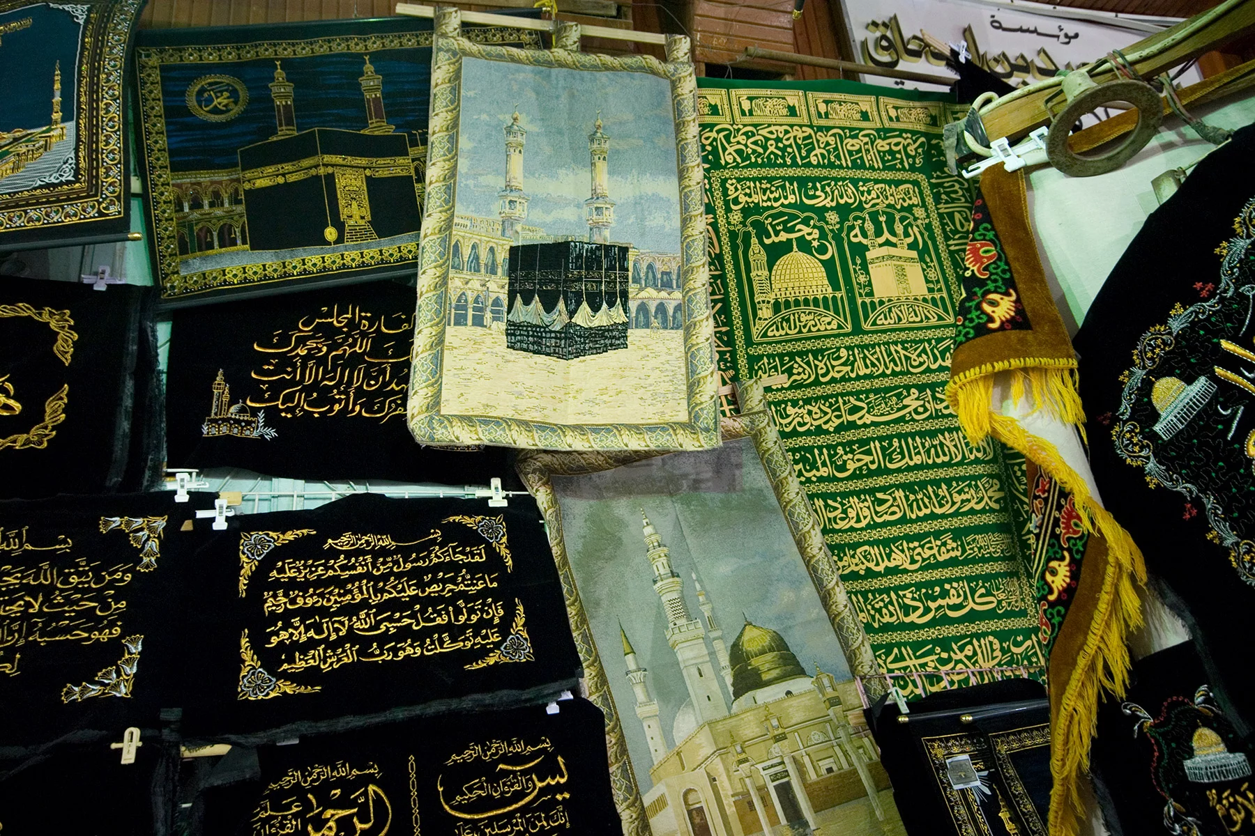A stall selling fabrics with images of Makkah including Arabic writing