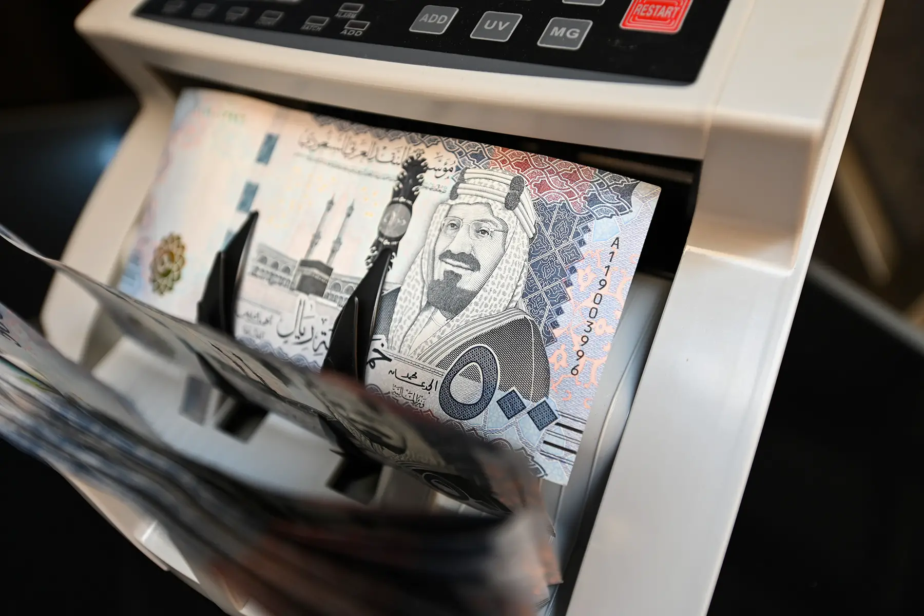 Saudi riyal banknotes in a counting machine