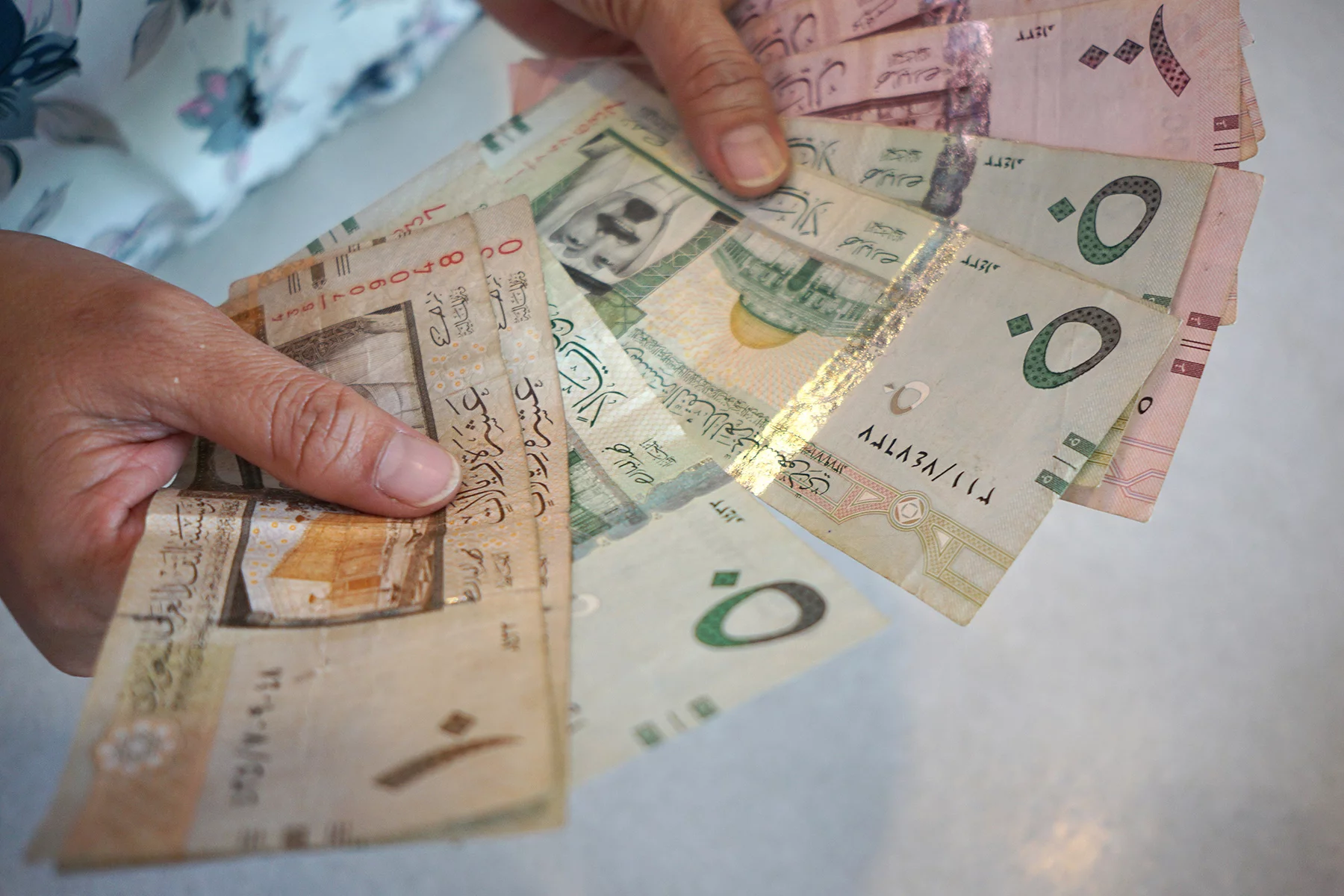 Woman holding Saudi riyal bills