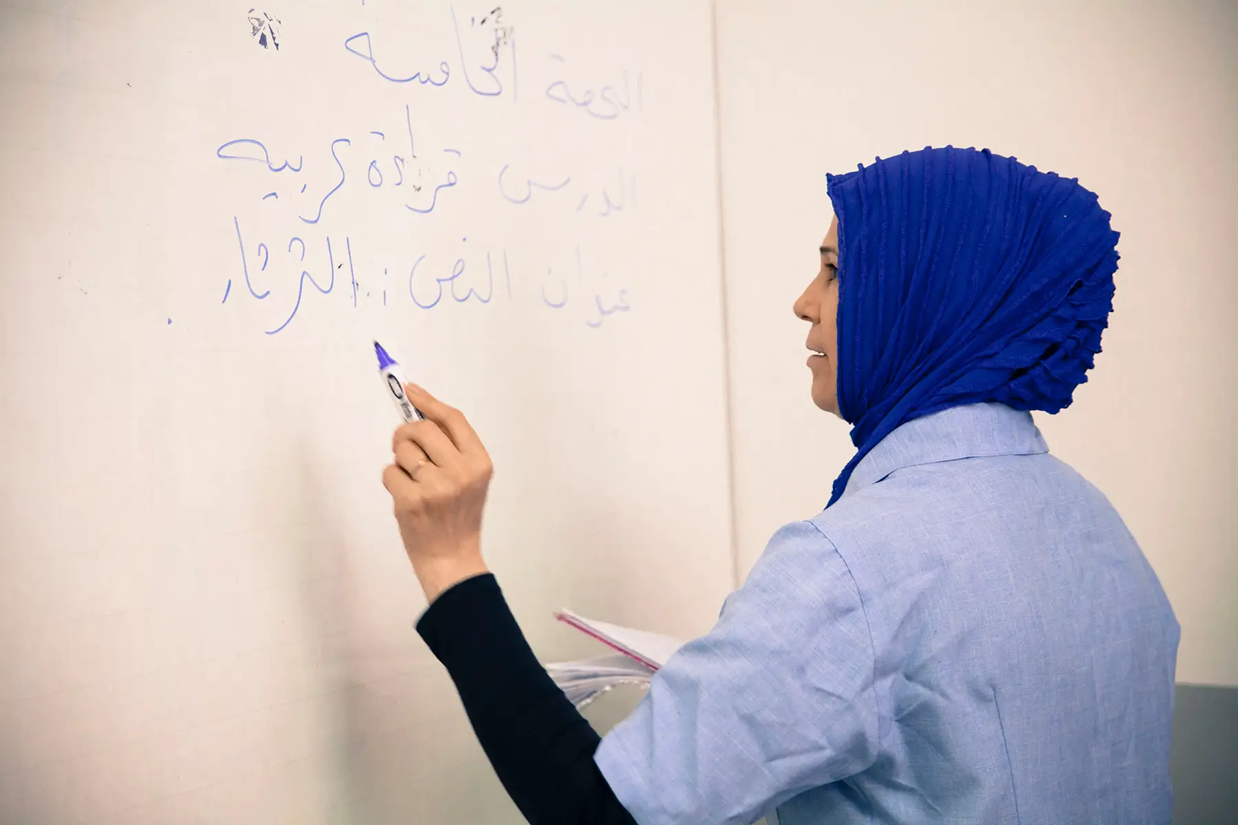 A woman writing in Arabic on a board in a lesson in an Arabic school in Foz do Iguaçu, Brazil