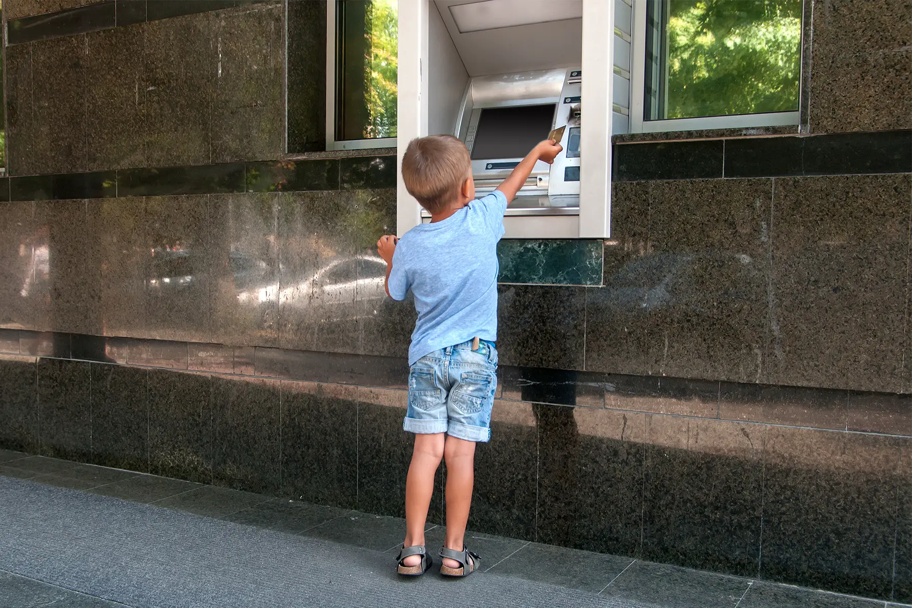 Young boy using ATM