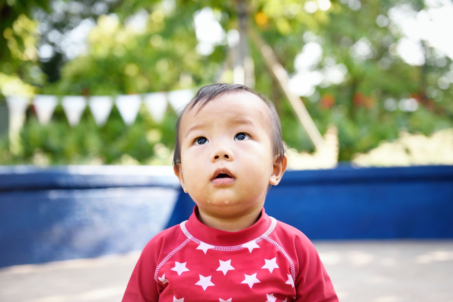 Close-up of baby wearing red top with white stars with mouth dropping open
