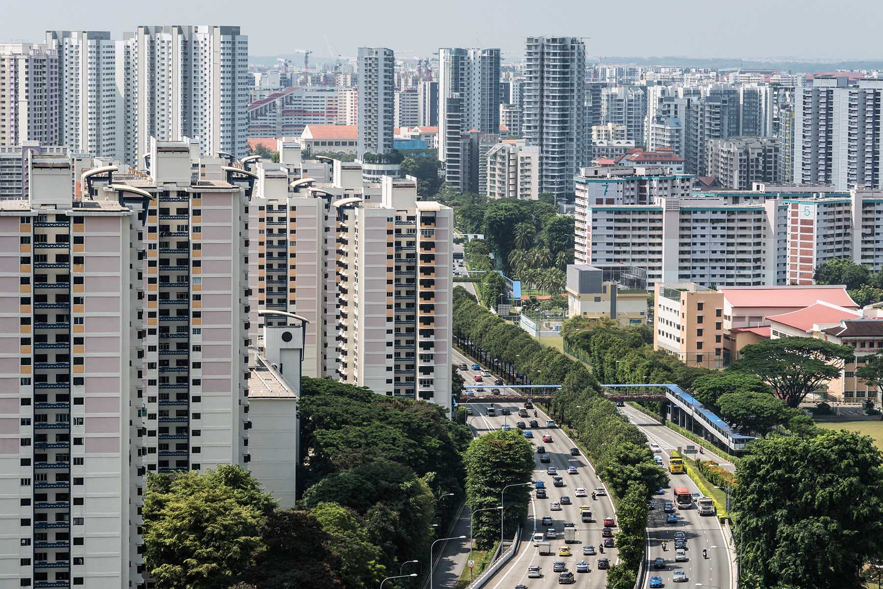 Aerial view of heavy traffic on highway in a residential district with many modern condo and apartment buildings in Singapore.