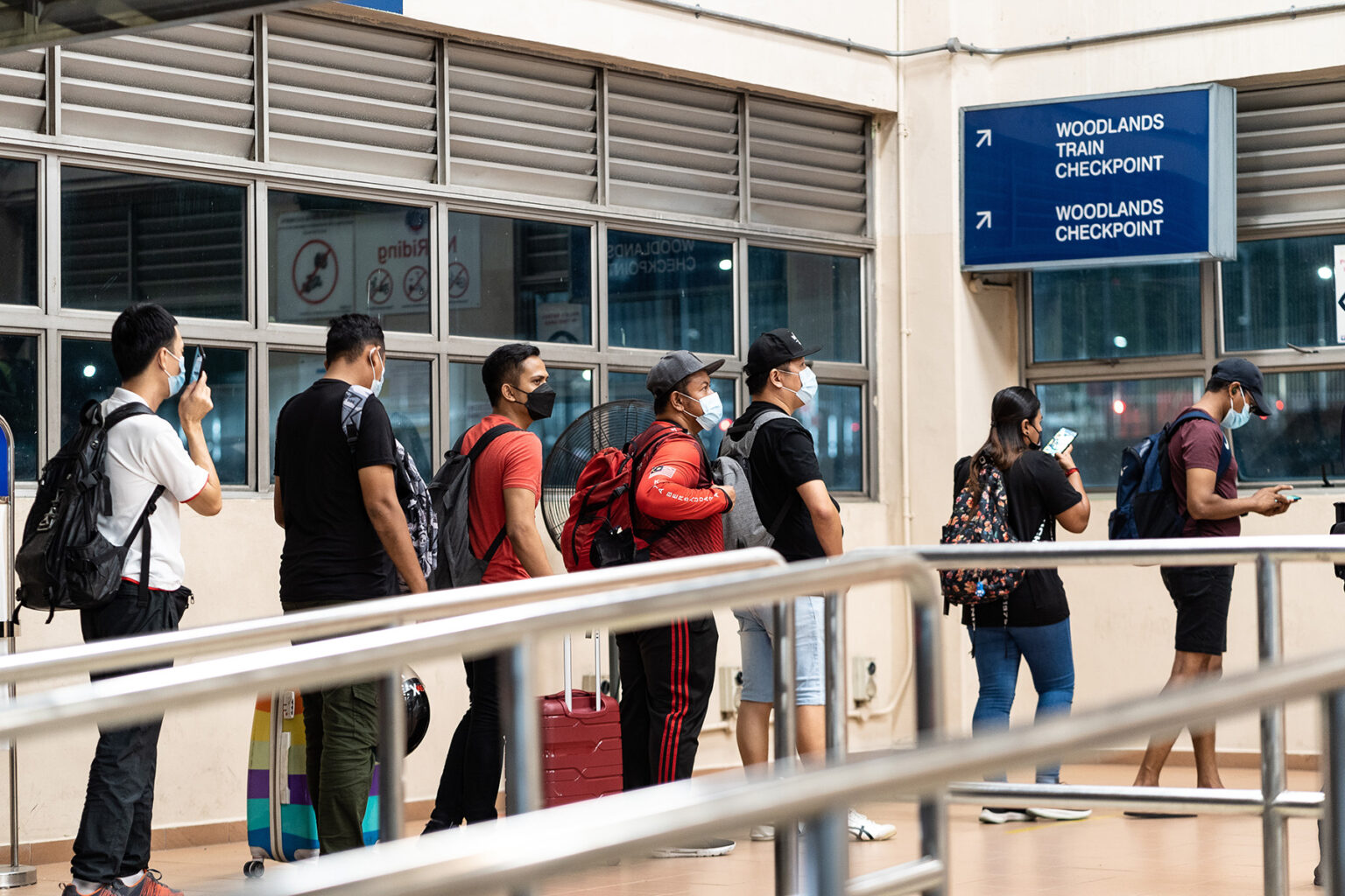 People standing in line for the immigration office in Singapore.