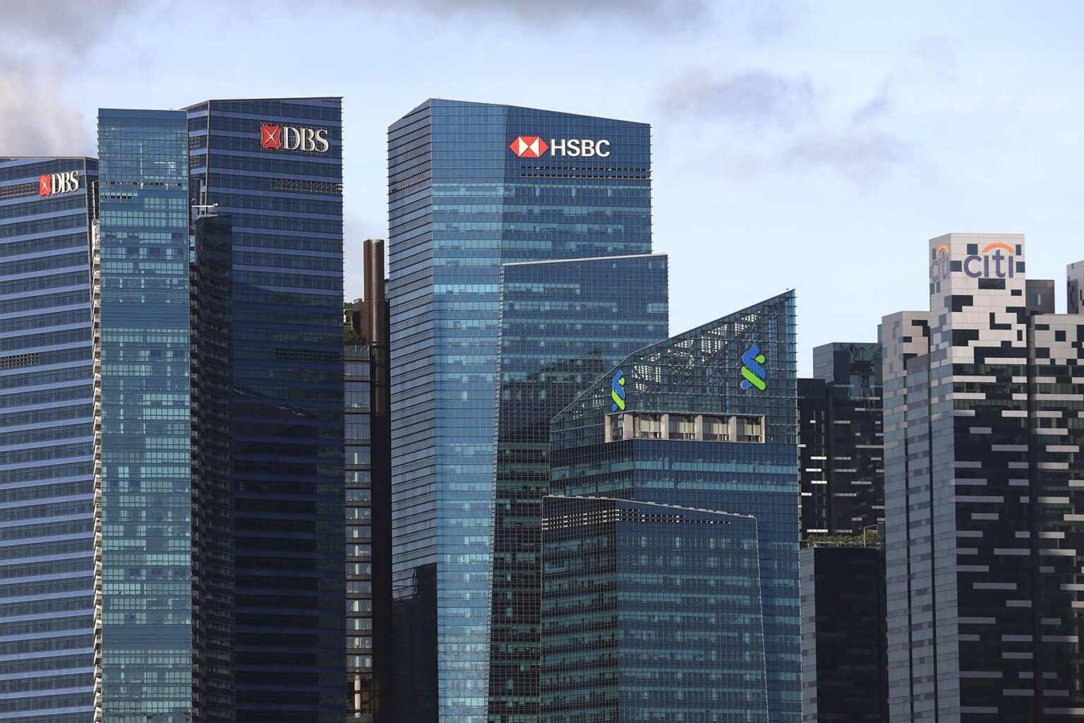 (L-R) The DBS Bank Ltd. , HSBC Holdings Plc, the Standard Chartered Plc and the Citigroup Inc. logos are displayed atop of a building in the central business district of Singapore.