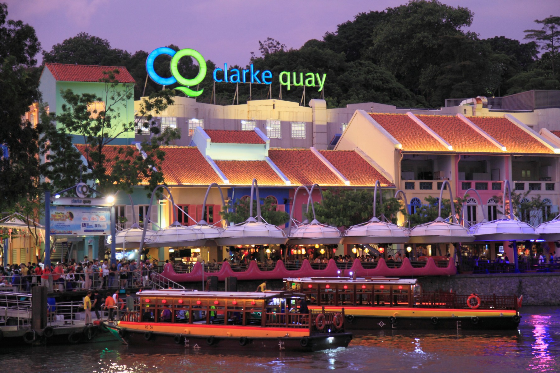 A nighttime shot of Clarke Quay, with busy bars and restaurants lit up along the Singapore River.