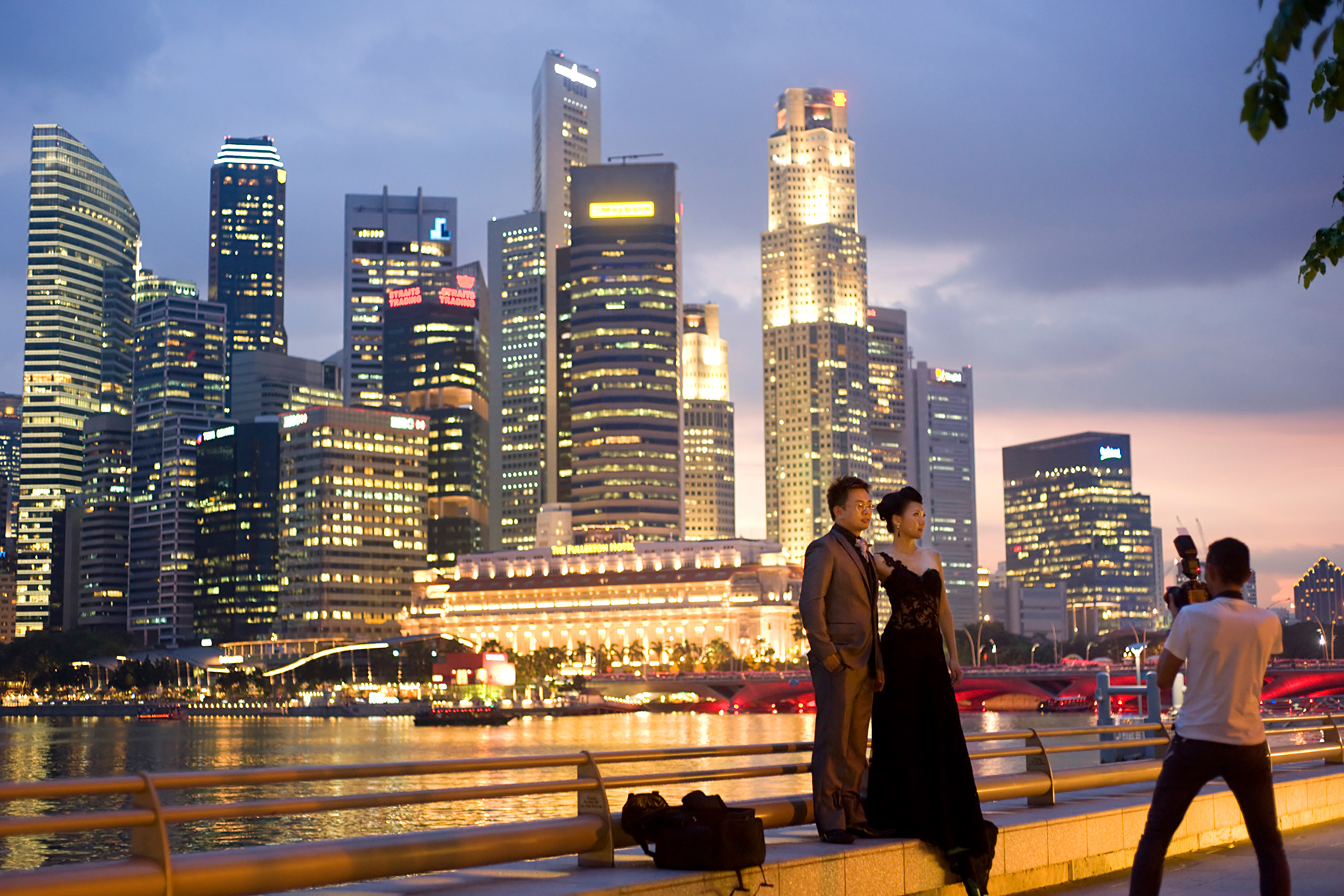A newly married couple being photographed in front of the Singapore skyline