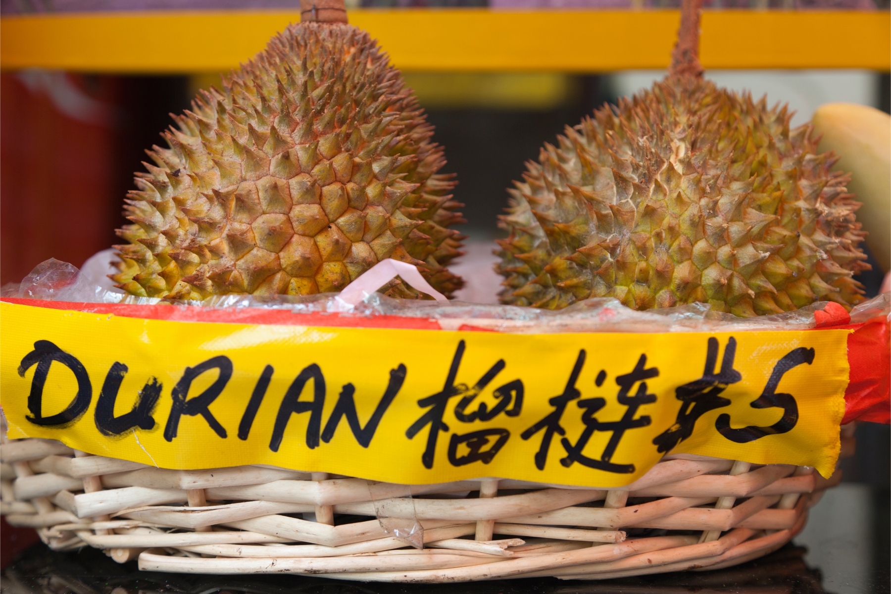 Two durian fruits for sale at a food market